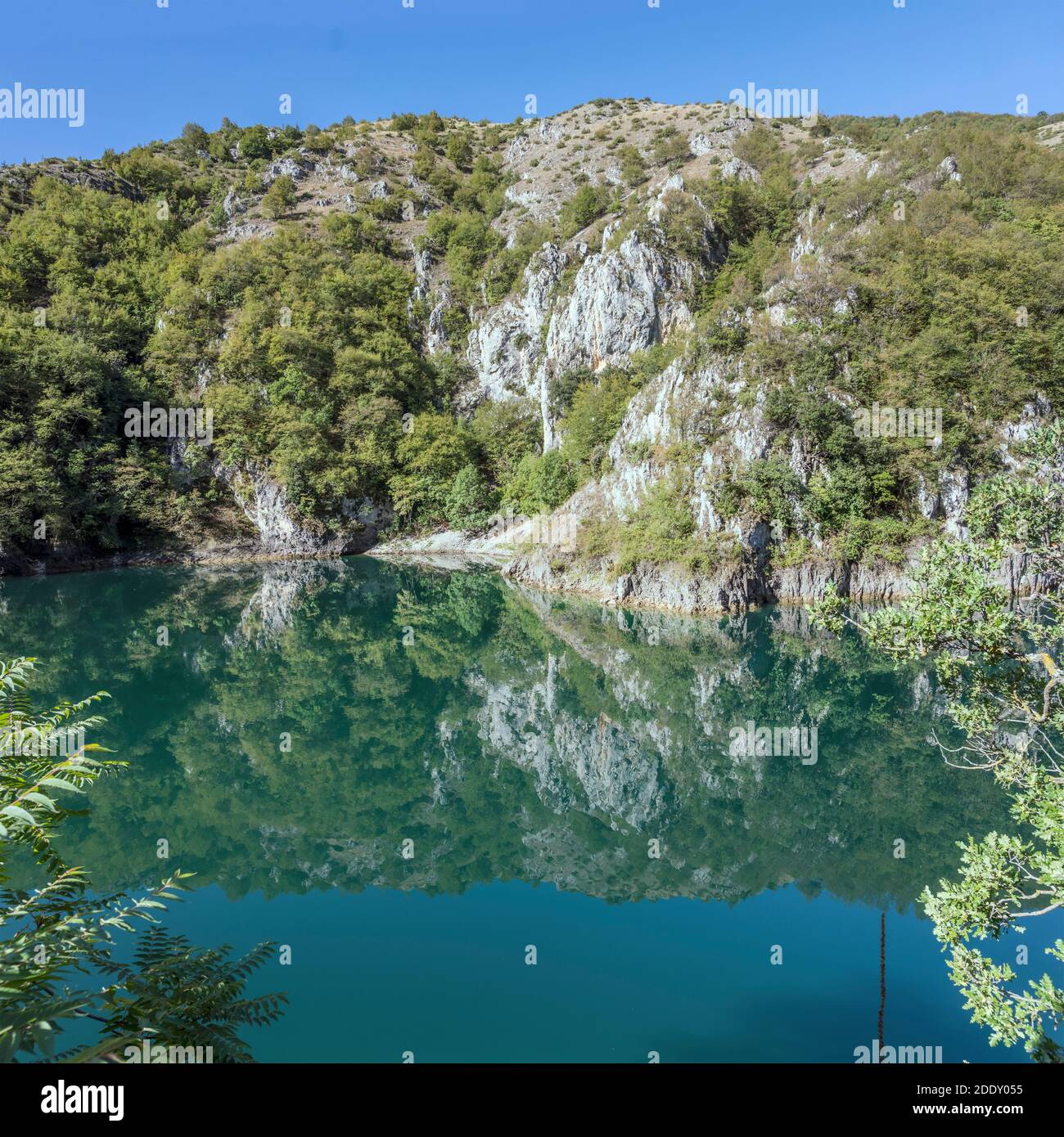 landscape with  harsh rocky slopes of Sagittario river gorge reflecting in blue water, shot in bright light near S.Domenico, L'Aquila, Abruzzo, Italy Stock Photo