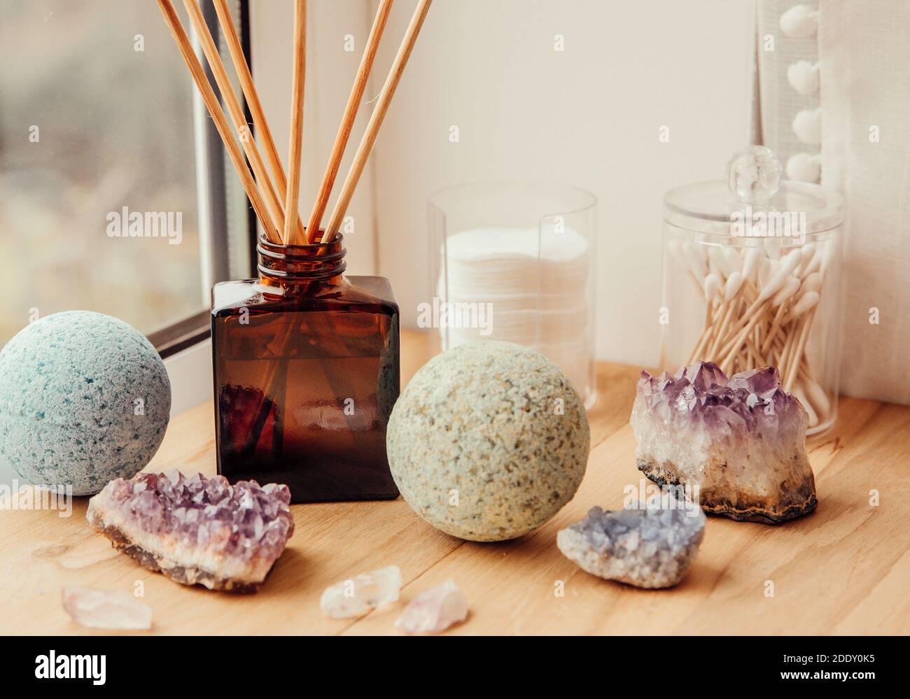 Natural wooden bathroom window sill with liquid diffuser bottle with wood sticks, natural light