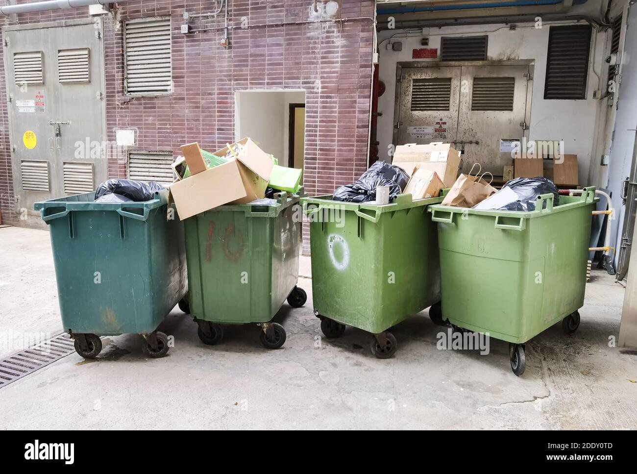 Large green commercial garbage bin with one side lid eft open Stock Photo -  Alamy