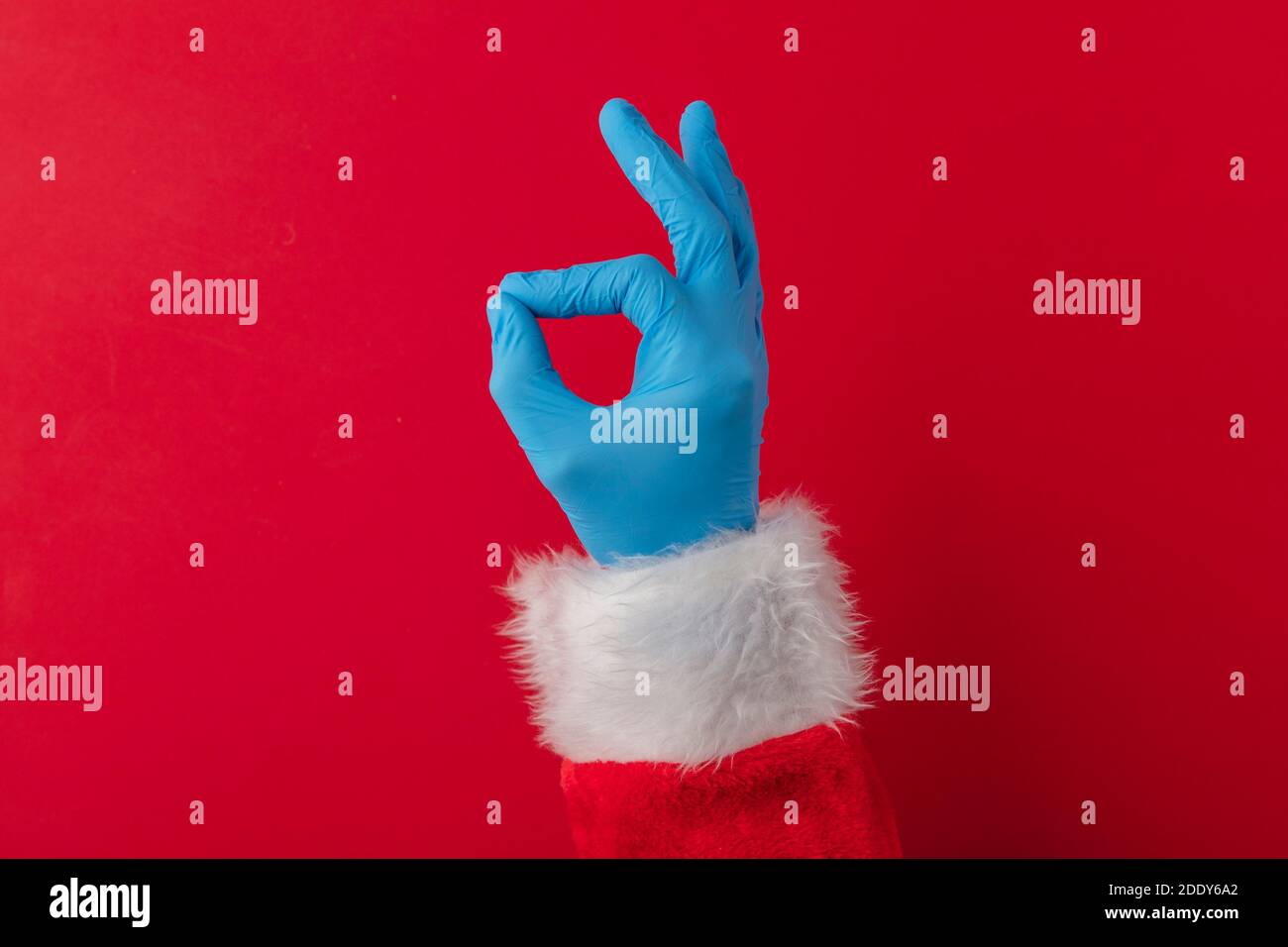 Santa hands wearing blue PPE protective gloves making OK hand gesture Stock Photo
