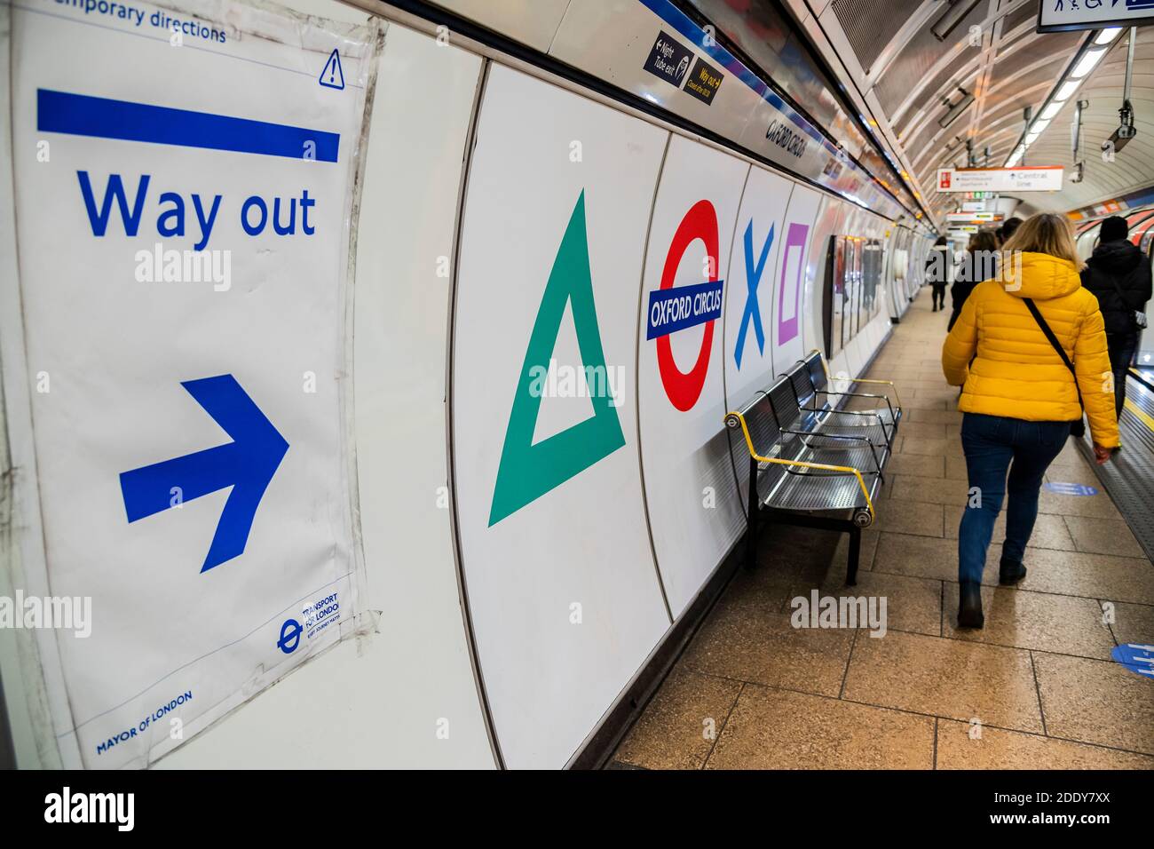 London, UK. 27 Nov 2020. In time for the arrival of the PS5 console signage at Oxford Circus has been updated with the console's trademark square, circle, triangle and cross. Inside the tube station the four symbols appear alongside the station name and roundel. By chance (or not) the Oxford Circus Microsoft store (maker of its main competitor the X-box) sits right outside one of these exits. People are still out in central london, despite the new lockdown which is now in force. Credit: Guy Bell/Alamy Live News Stock Photo