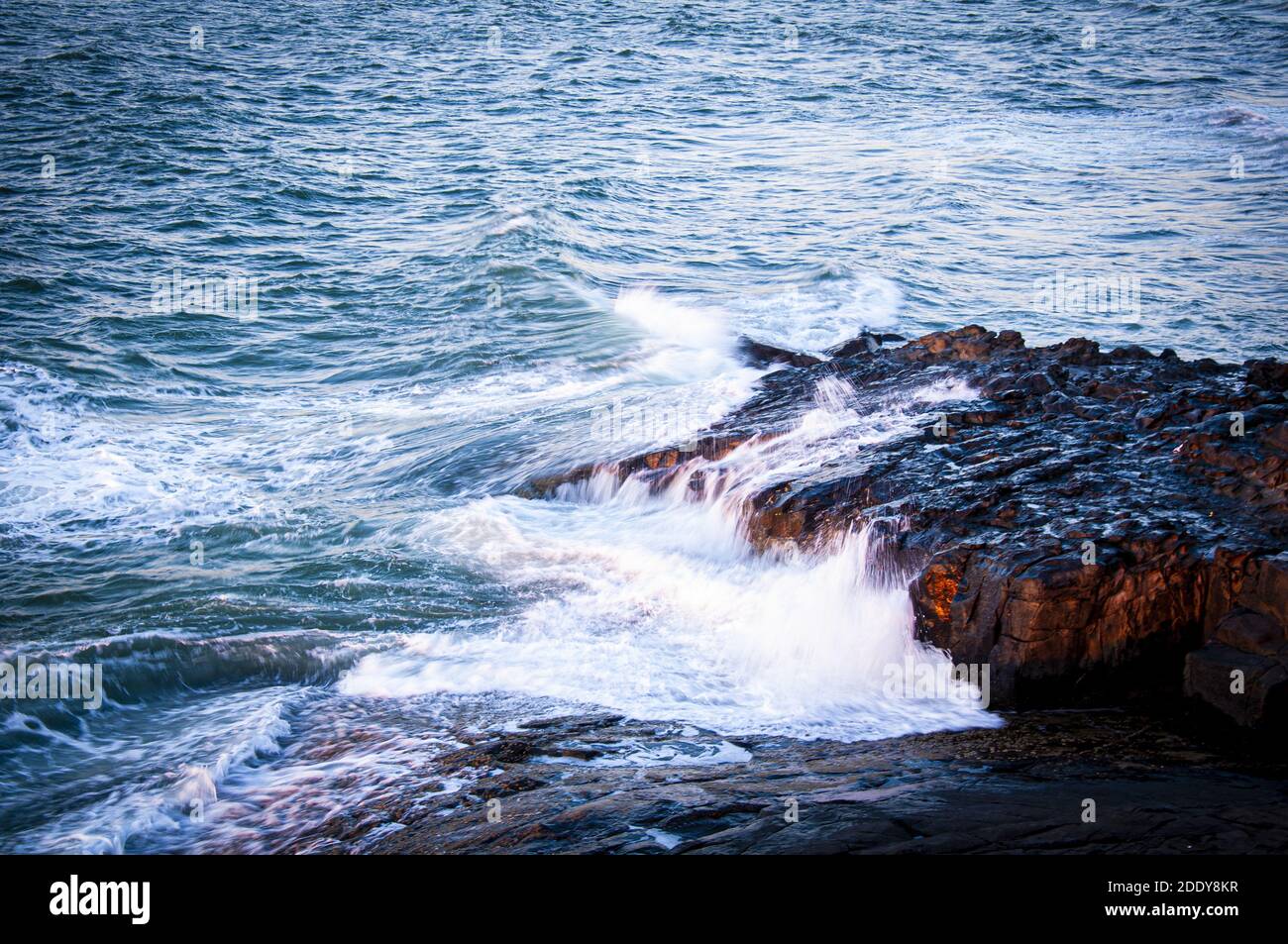 A beautiful shot of sea waves hitting rocks on the beach Stock Photo ...