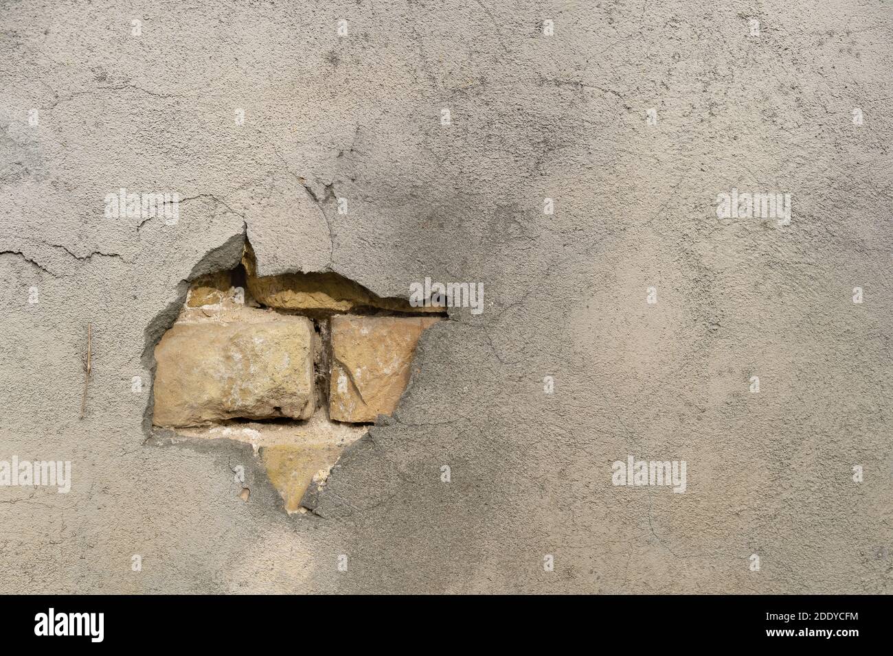 the texture of the building's cladding with a piece falling out with a gap on a crumbling brick wall. Background of brick wall pattern Stock Photo