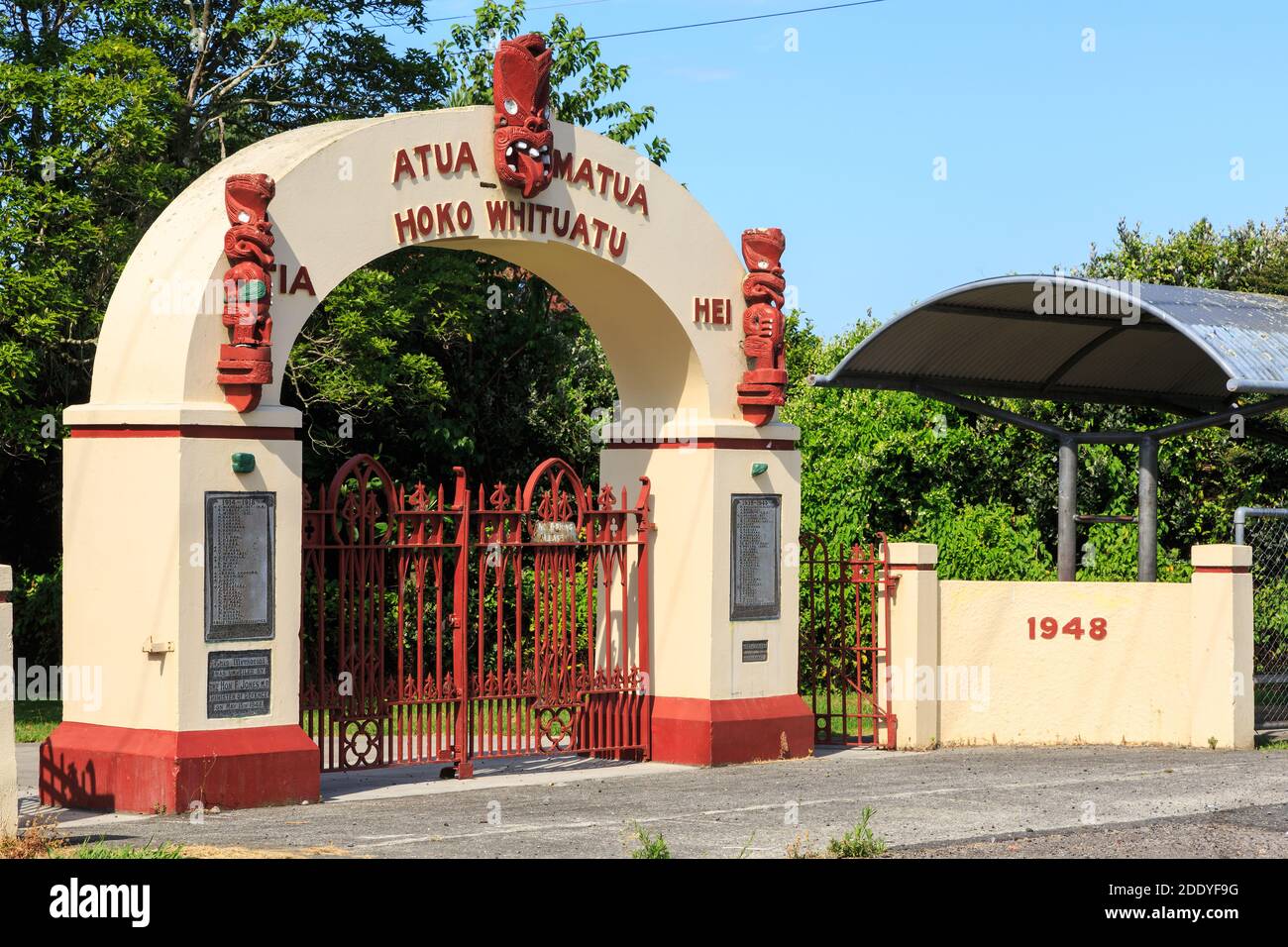 War memorial gates (erected 1948) with Maori artwork outside Te Matai School near Te Puke, New Zealand Stock Photo