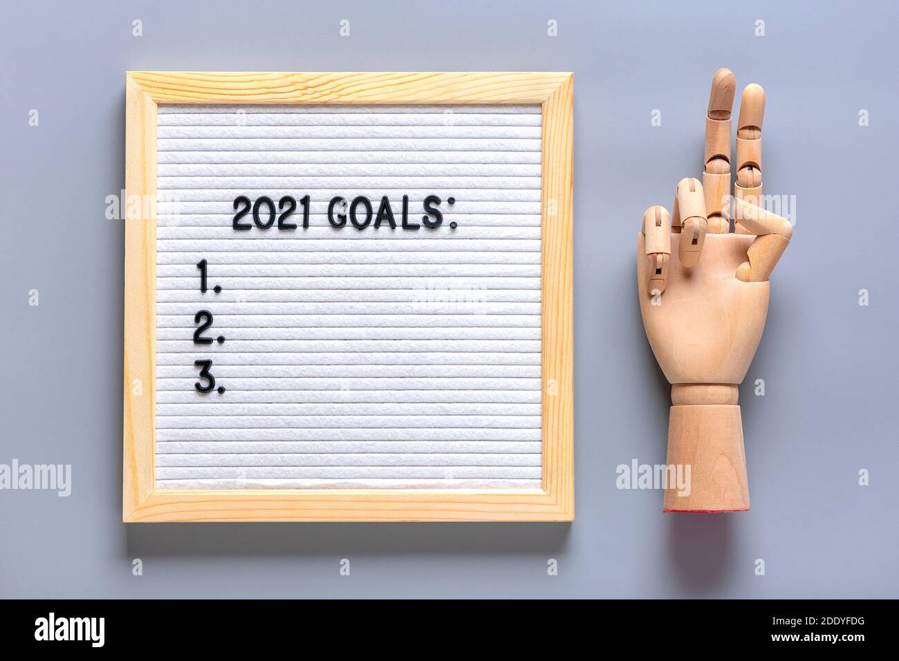 Text - 2021 goals Motivational quote on message felt board, wooden hand on gray background Planning, self motivation, achievement, success, wish list Stock Photo