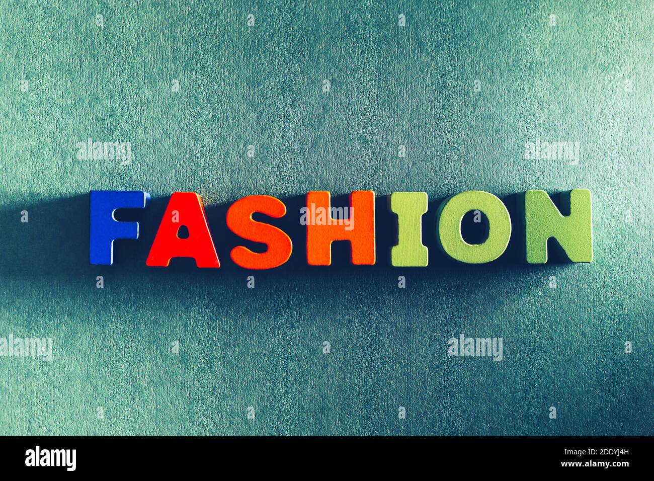 Colorful word text Fashion inscription by wooden painted abc letters at craft paper textured blue background, high couture, vogue and style concept Stock Photo
