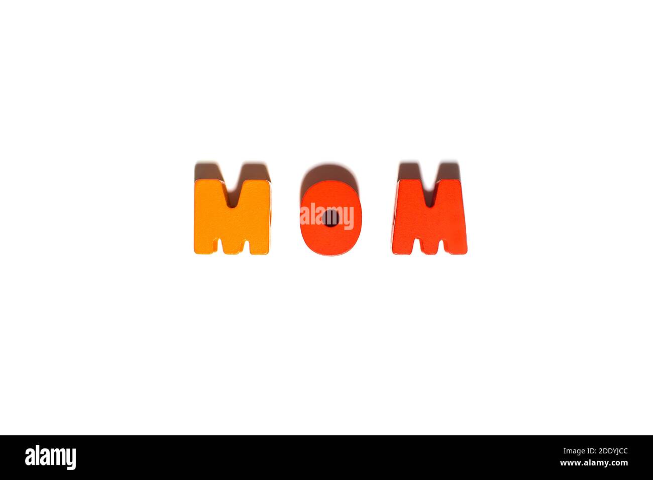 Wooden letters spelling word text Mom in orange and yellow colors at isolated white background with shadows, family, love, motherhood concept, top vie Stock Photo