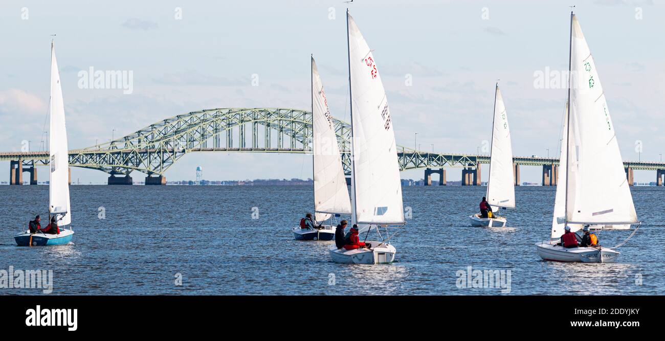 Babylon, New York, USA – 7 December 2019: Two person sailboats in a winter regatta with the Great South Bay Bridge in the background on Long Island Ne Stock Photo