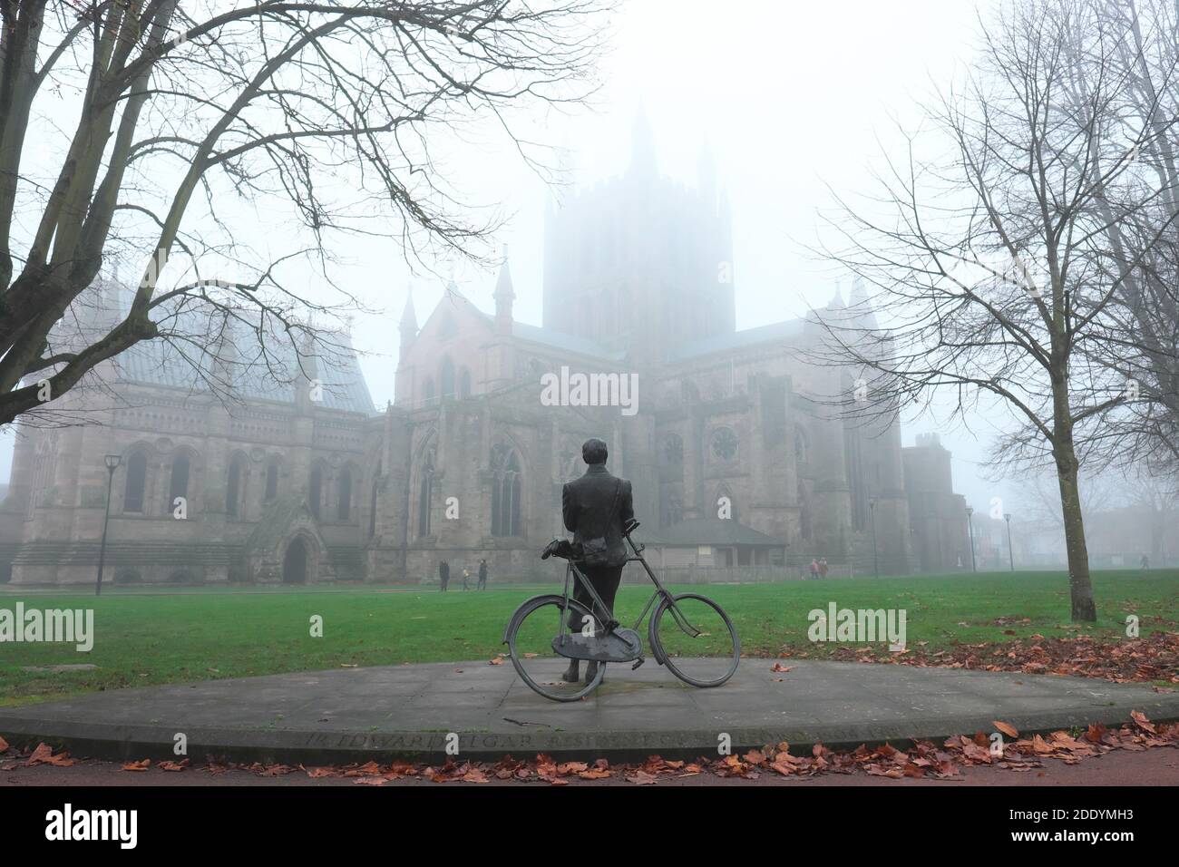 Hereford, Herefordshire, UK - Friday 27th November 2020 - UK Weather - Fog continues to linger in Hereford at lunchtime - A statue of composer Sir Edward Elgar gazes up at the fog covered tower of Hereford Cathedral - the central tower is 165ft tall. Photo Steven May / Alamy Live News Stock Photo