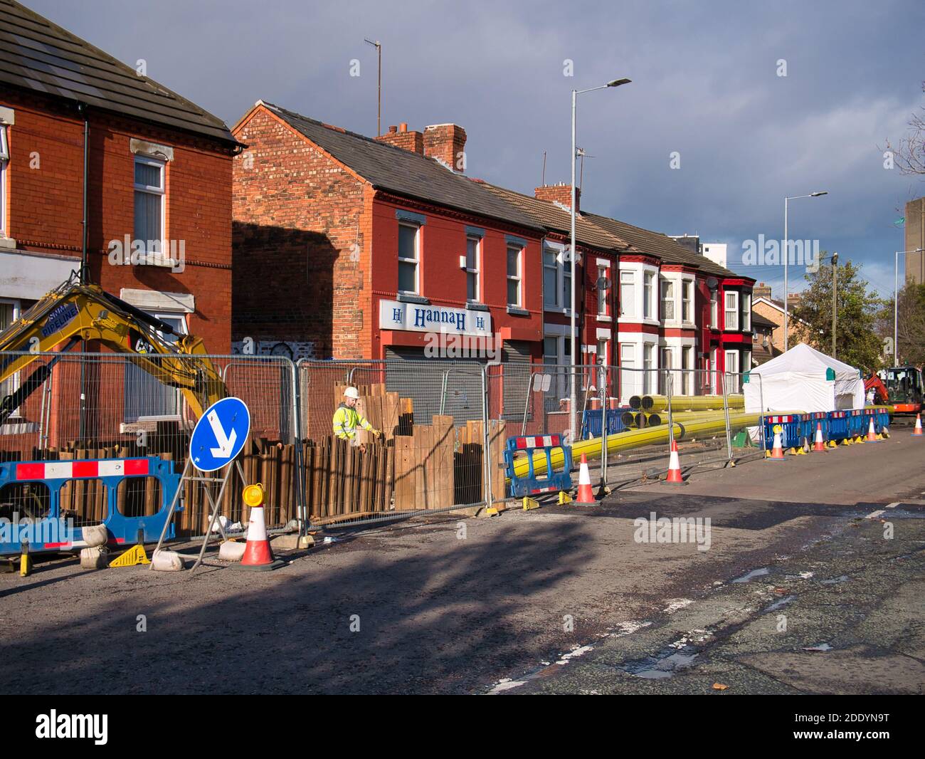 Traffic is diverted around an excavated area of road as replacement gas mains pipeline is laid. The new pipe is of a yellow, flexible plastic type. Stock Photo