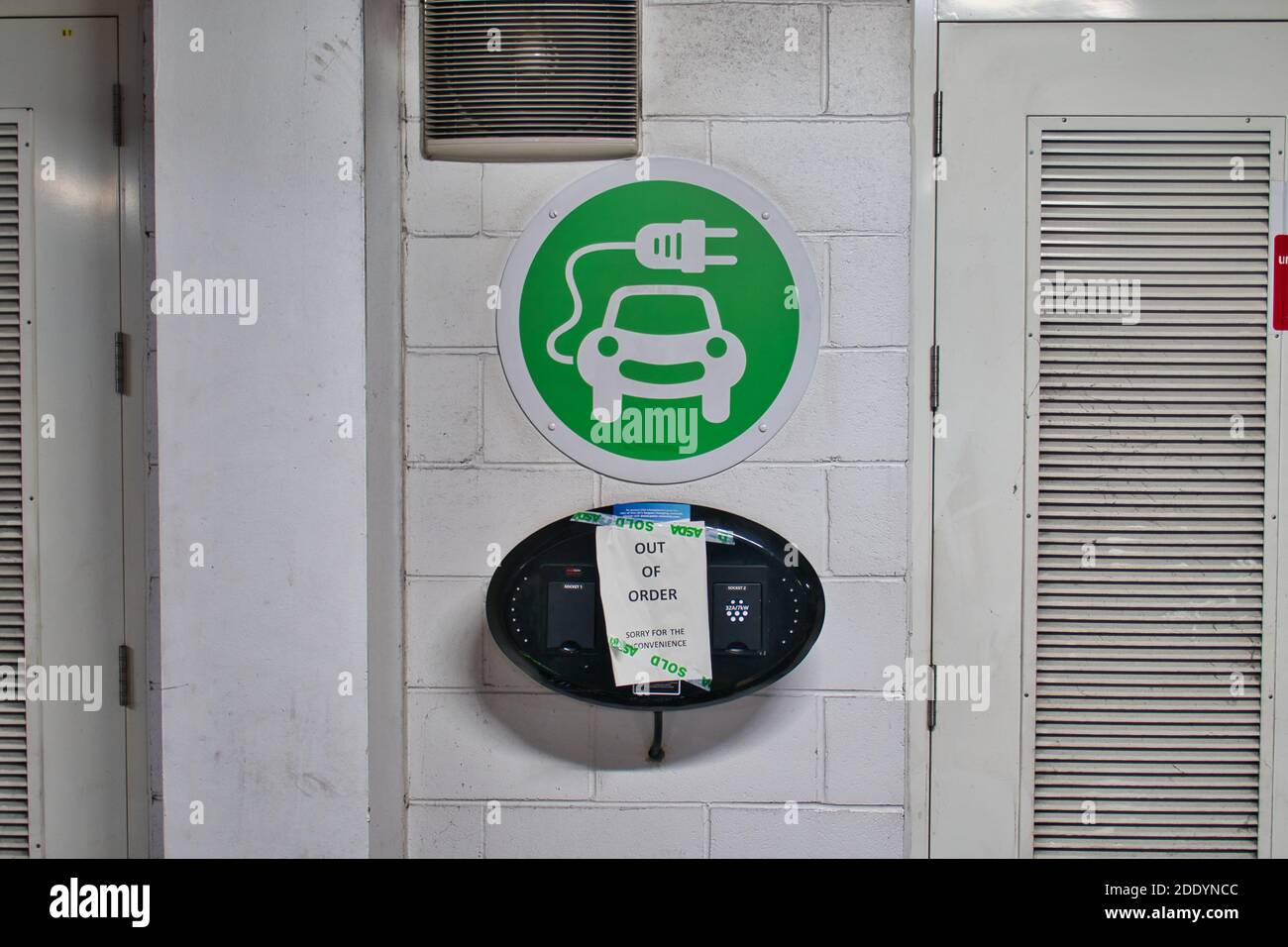 A sign on an electric vehicle (EV) charging point says that it is out of order. Taken in the car park of a branch of the UK ASDA supermarket. Stock Photo