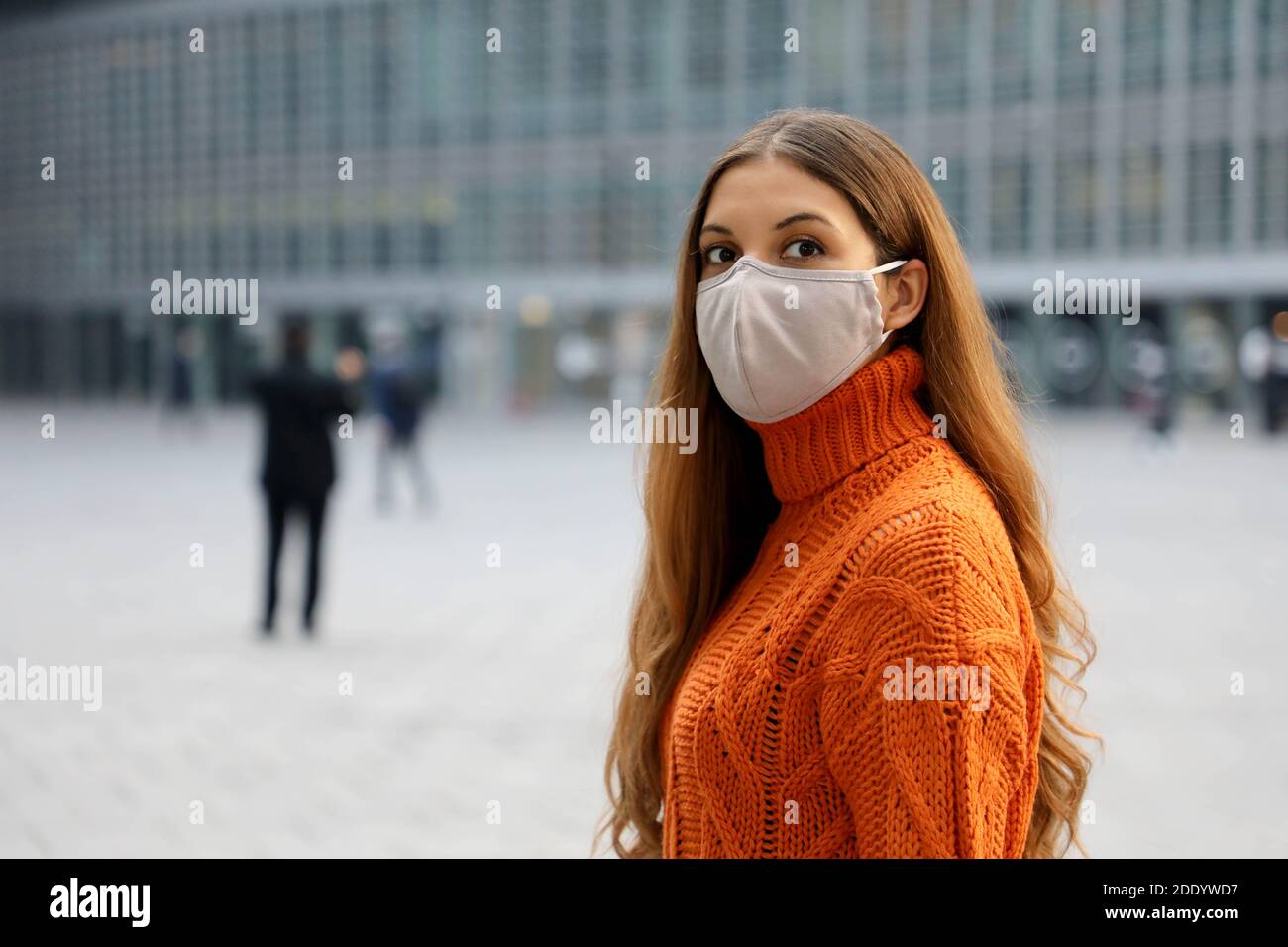 Portrait of a young business woman wearing protective mask standing on the street looking in front of her worried. Copy space. Stock Photo