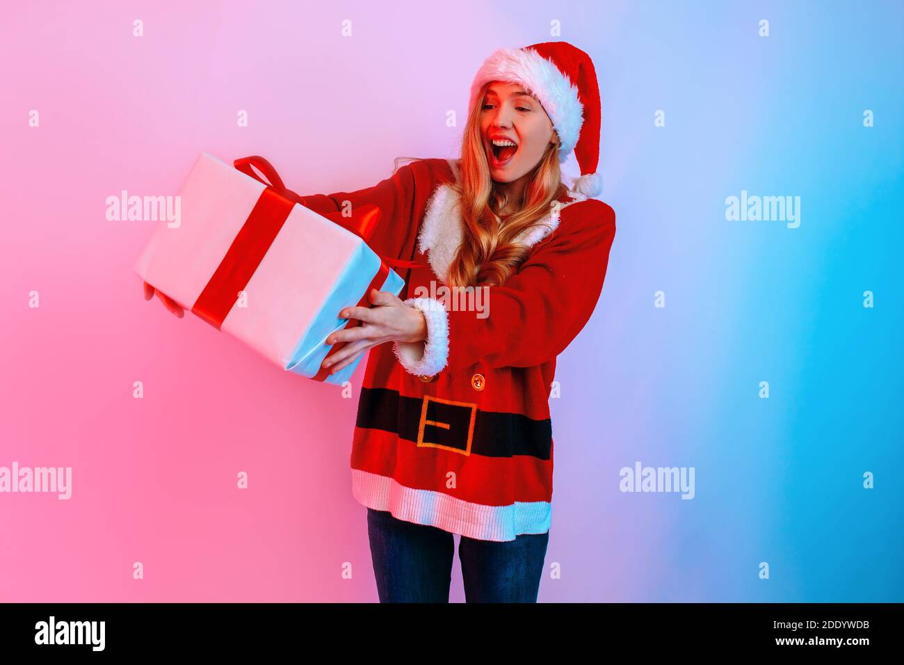Happy excited shocked young woman in Santa hat with gift box, on ...