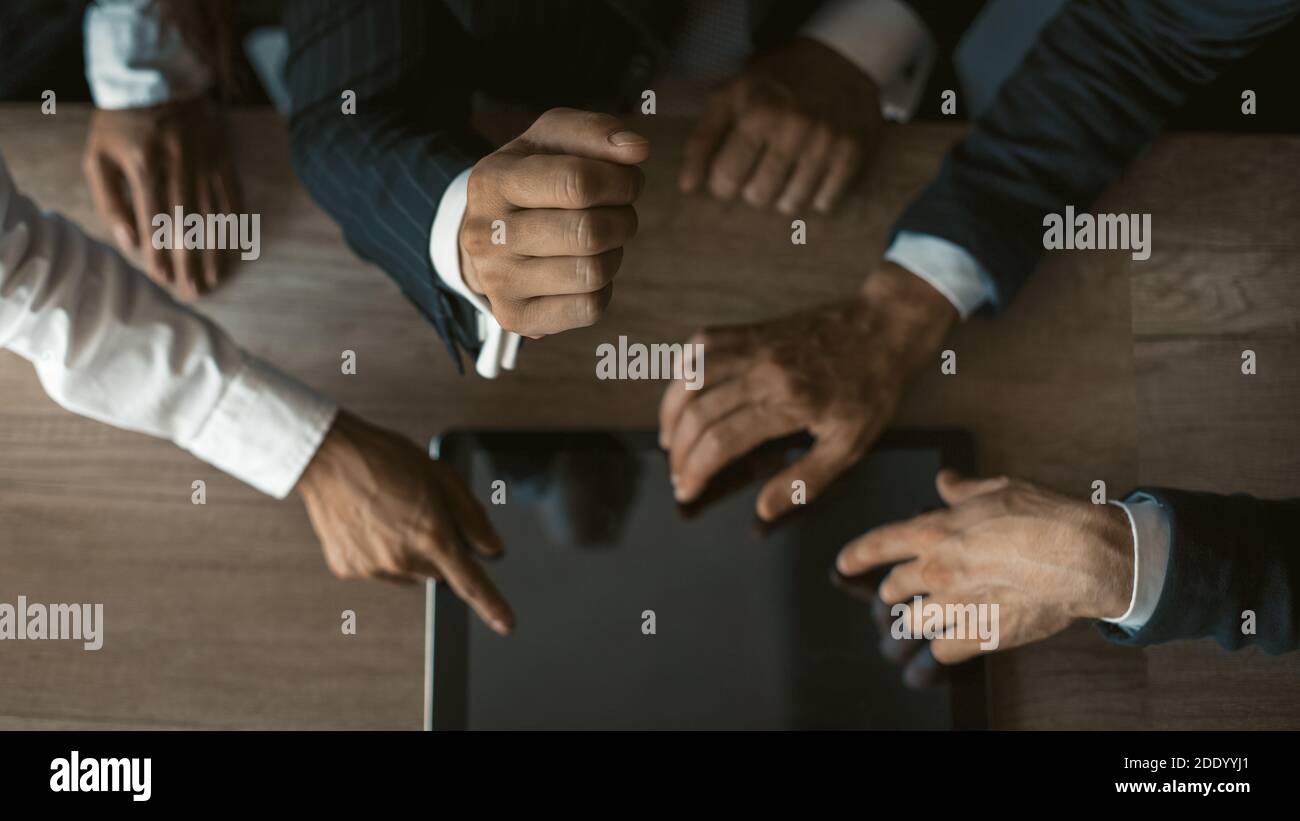 Team of freelance developers using digital tablet checking out new app updates. Hands of business people touching screen of electronic device. Close Stock Photo