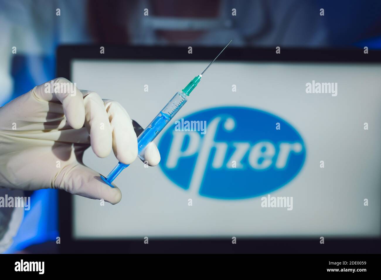 new york , 11.10.2020: Hand holding covid-19 vaccine with Pfizer logo in the background Stock Photo