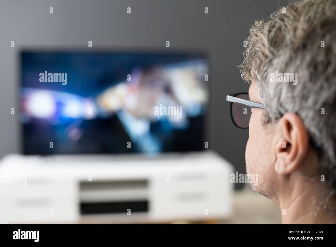 Man Watching TV Movie Or Television In Glasses Stock Photo