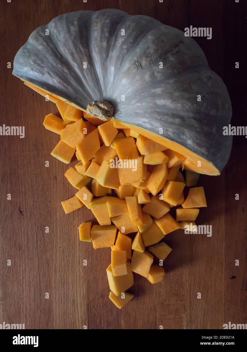 Half pumpkin and pumpkin dice on wooden board Stock Photo - Alamy