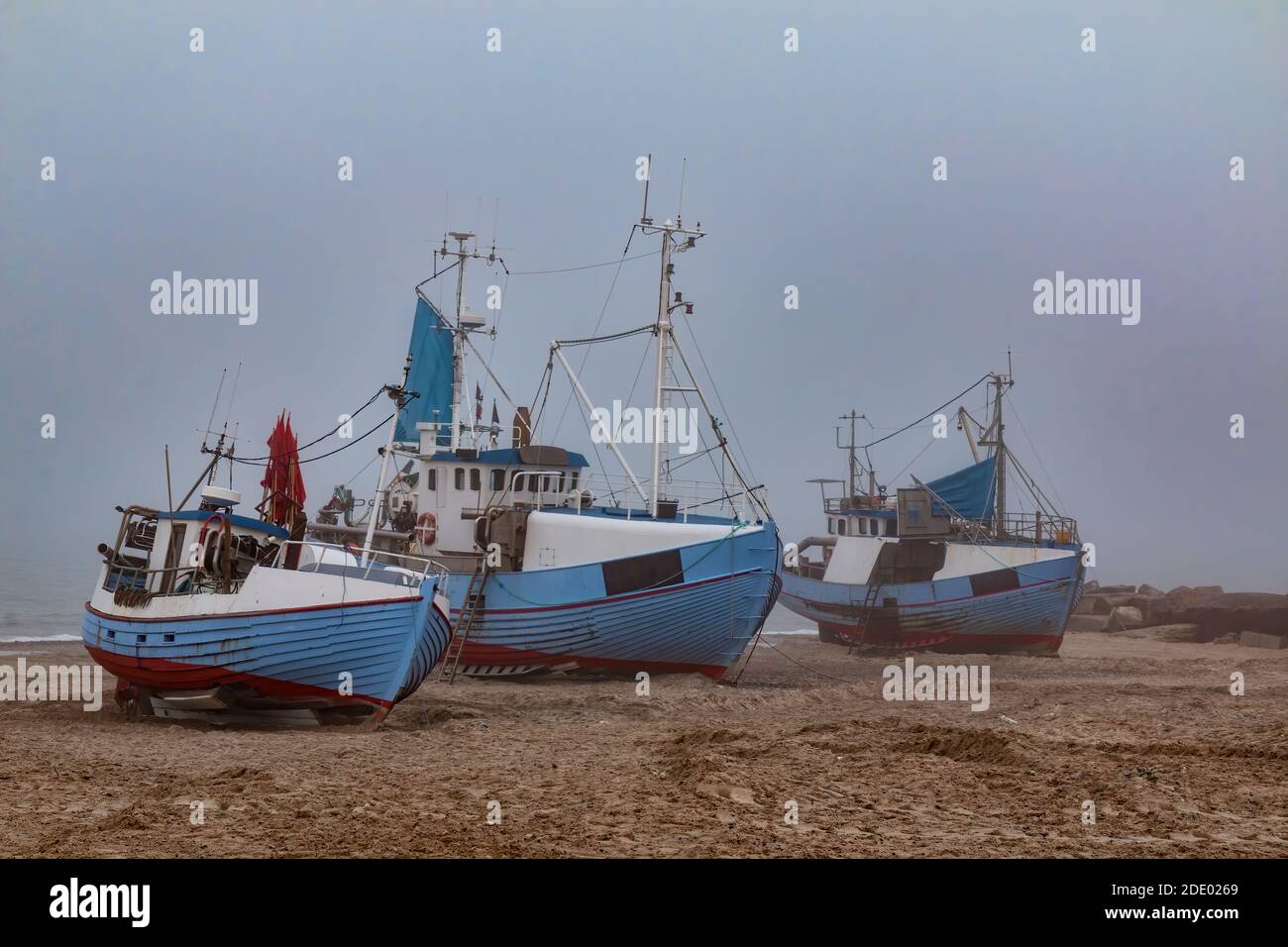 Fishing cutters on the beach on the west coast of Denmark on a foggy day Stock Photo