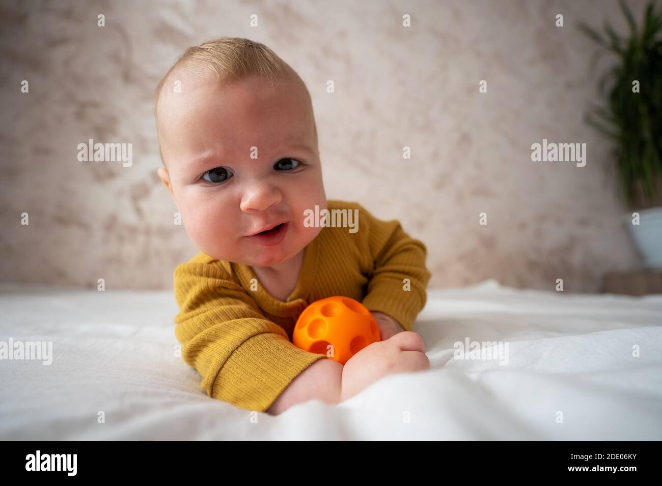Cute baby playing with ball on bed Stock Photo Alamy