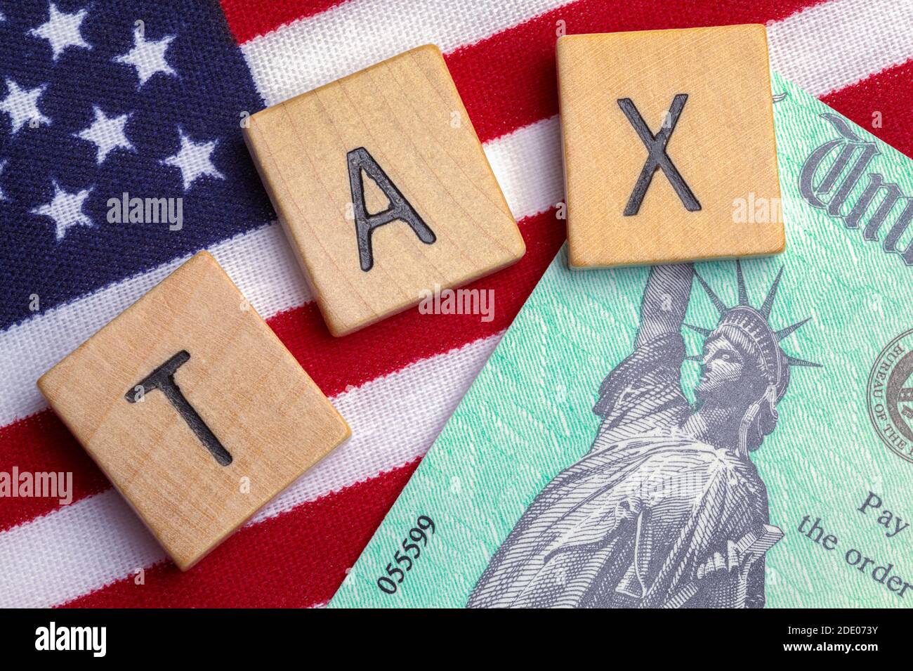 Tax Refund Check with USA Flag and Wood Blocks Spelling TAX. Stock Photo