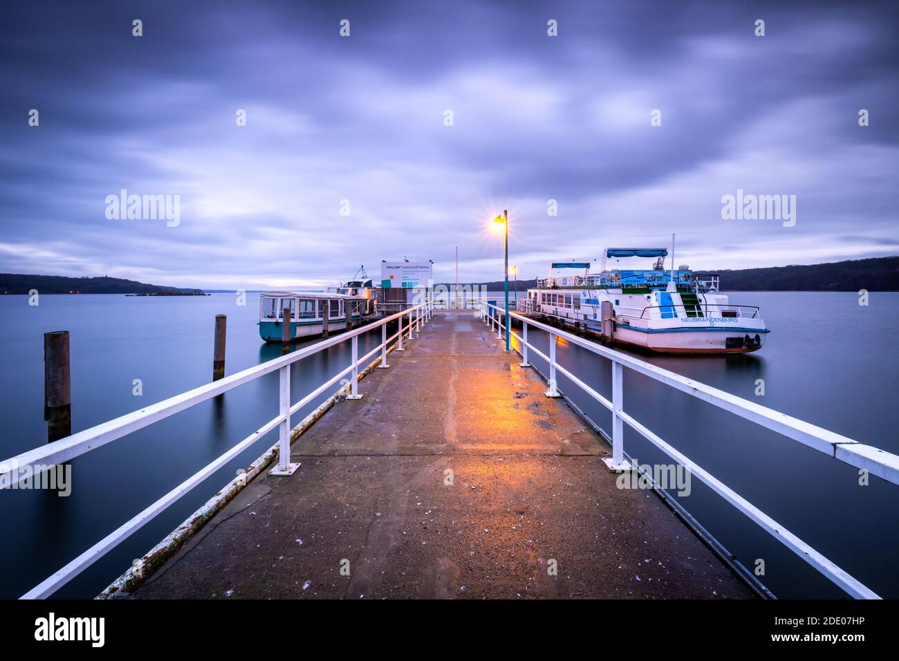 Excursion boat at a boat jetty at the blue hour Stock Photo