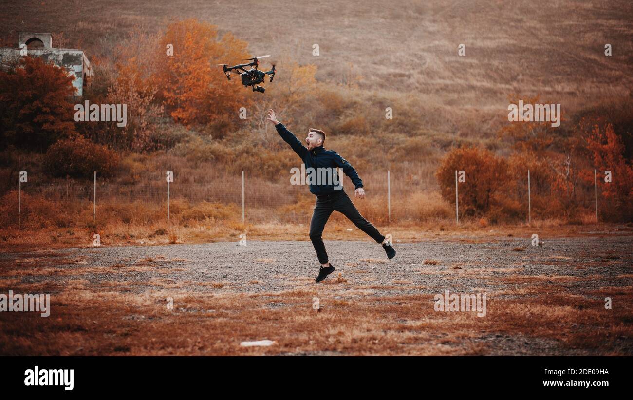 Crazy man try to catch a drone Stock Photo