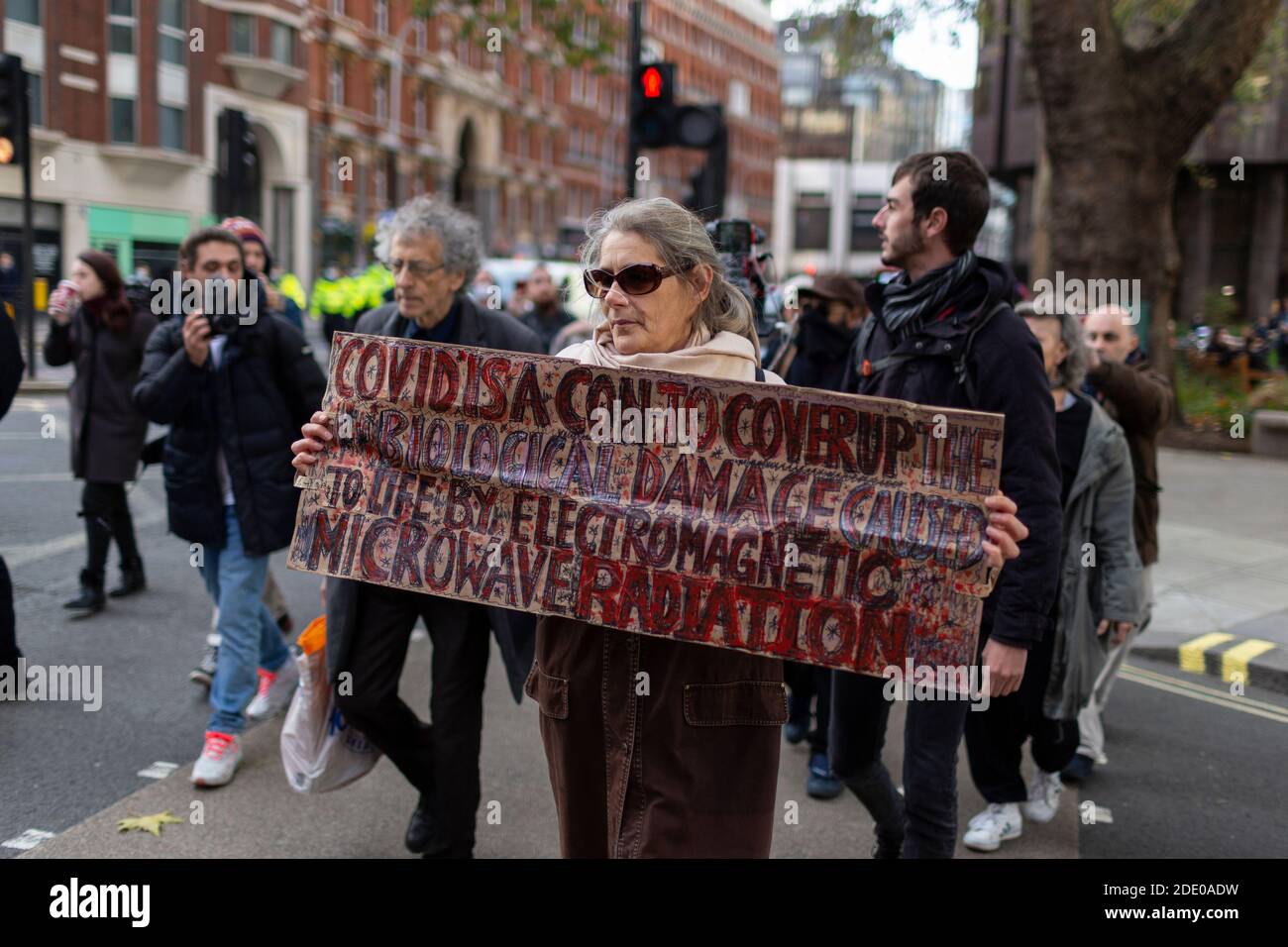 Protester marching with a placard during anti-vaccination protest, Victoria, London, 24 November 2020 Stock Photo