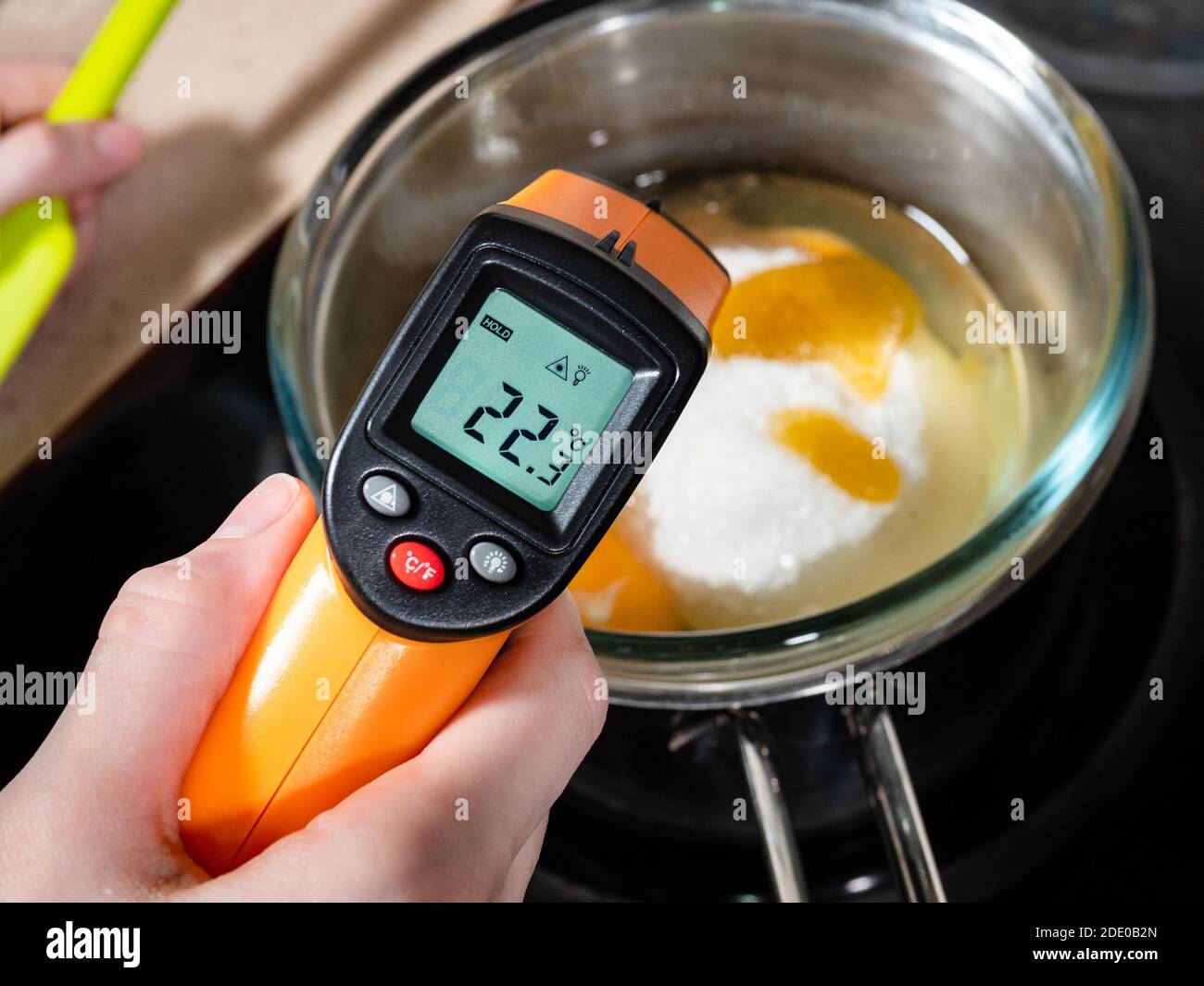 https://c8.alamy.com/comp/2DE0B2N/cooking-sweet-sponge-cake-at-home-measuring-temperature-of-ingredients-in-glass-bowl-on-water-bath-by-infrared-thermometer-on-stove-at-home-kitchen-2DE0B2N.jpg