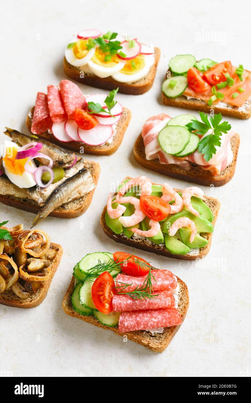 Set of different sandwiches with meat, vegetables, seafood. Assortment open sandwiches on light