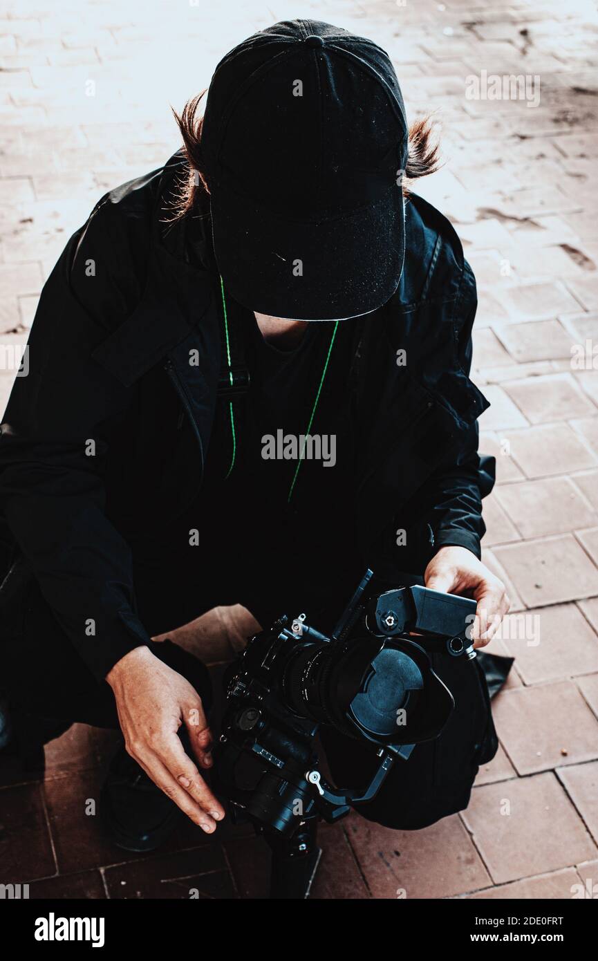 Haired guy from shooting team corrects focus on camera Stock Photo
