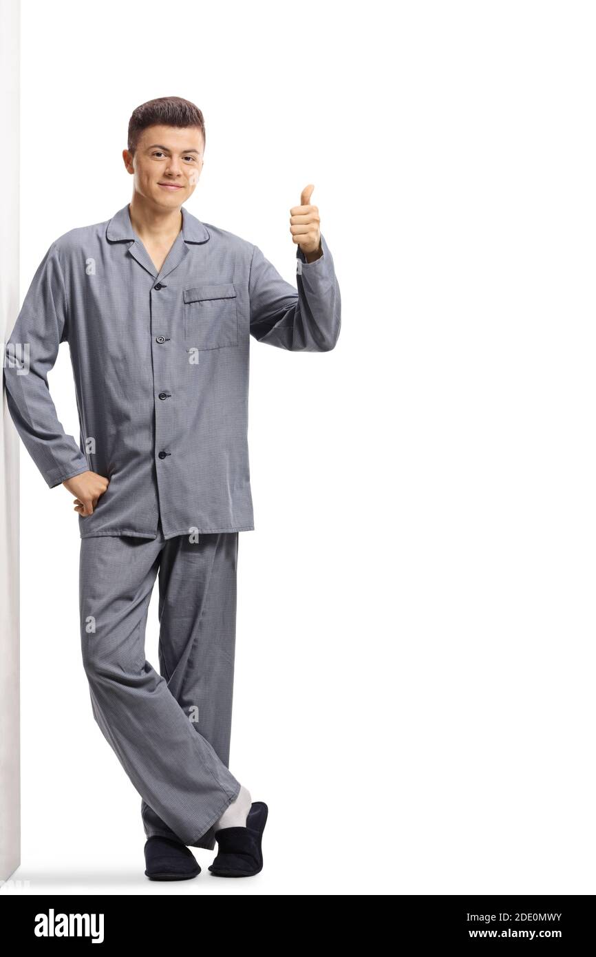 Full length portrait of a guy in pajamas leaning on a wall and ...