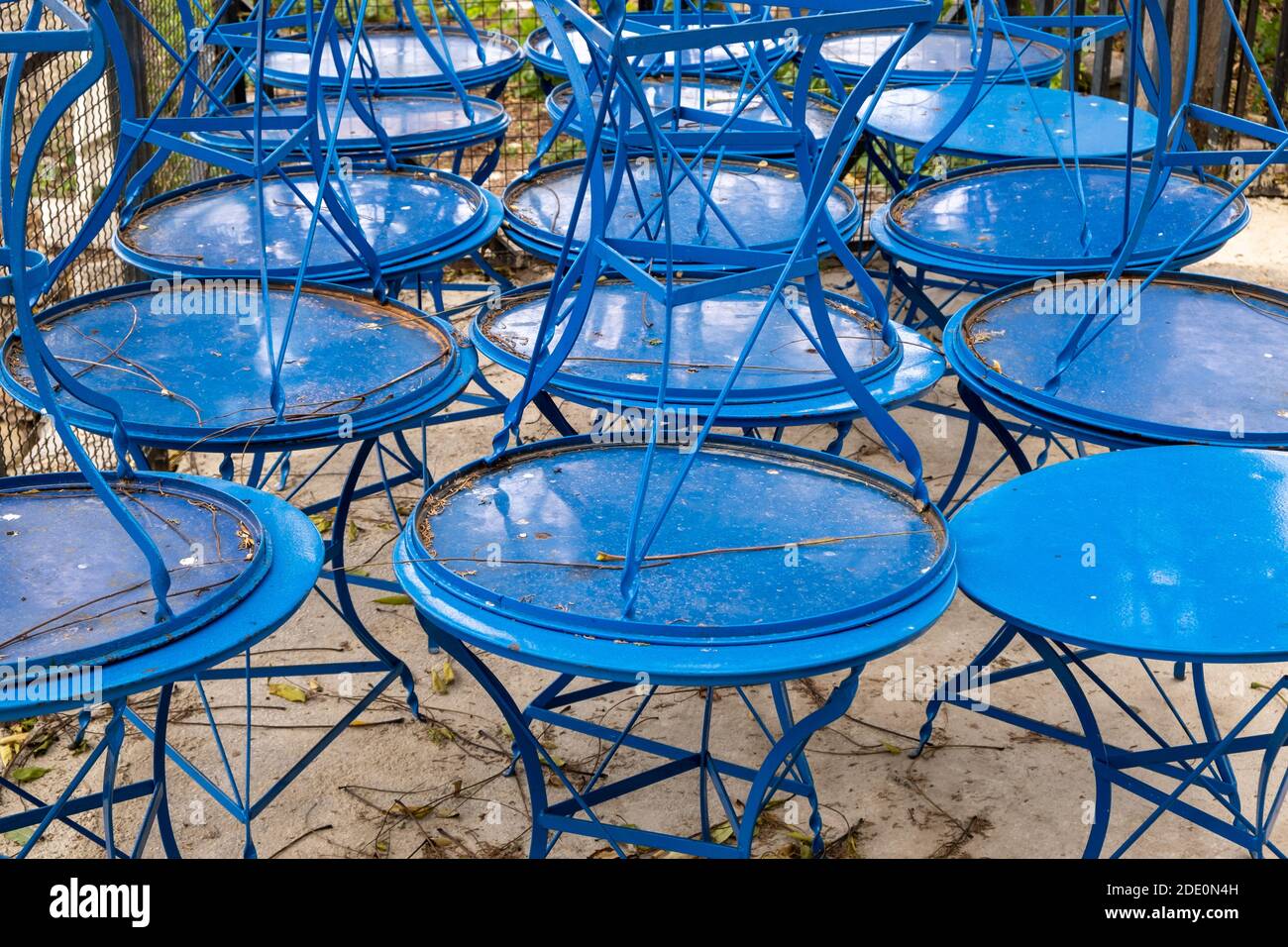 Cafe tables stack, closed business, Covid19 Pandemic lockdown. Blue metal tables stacked