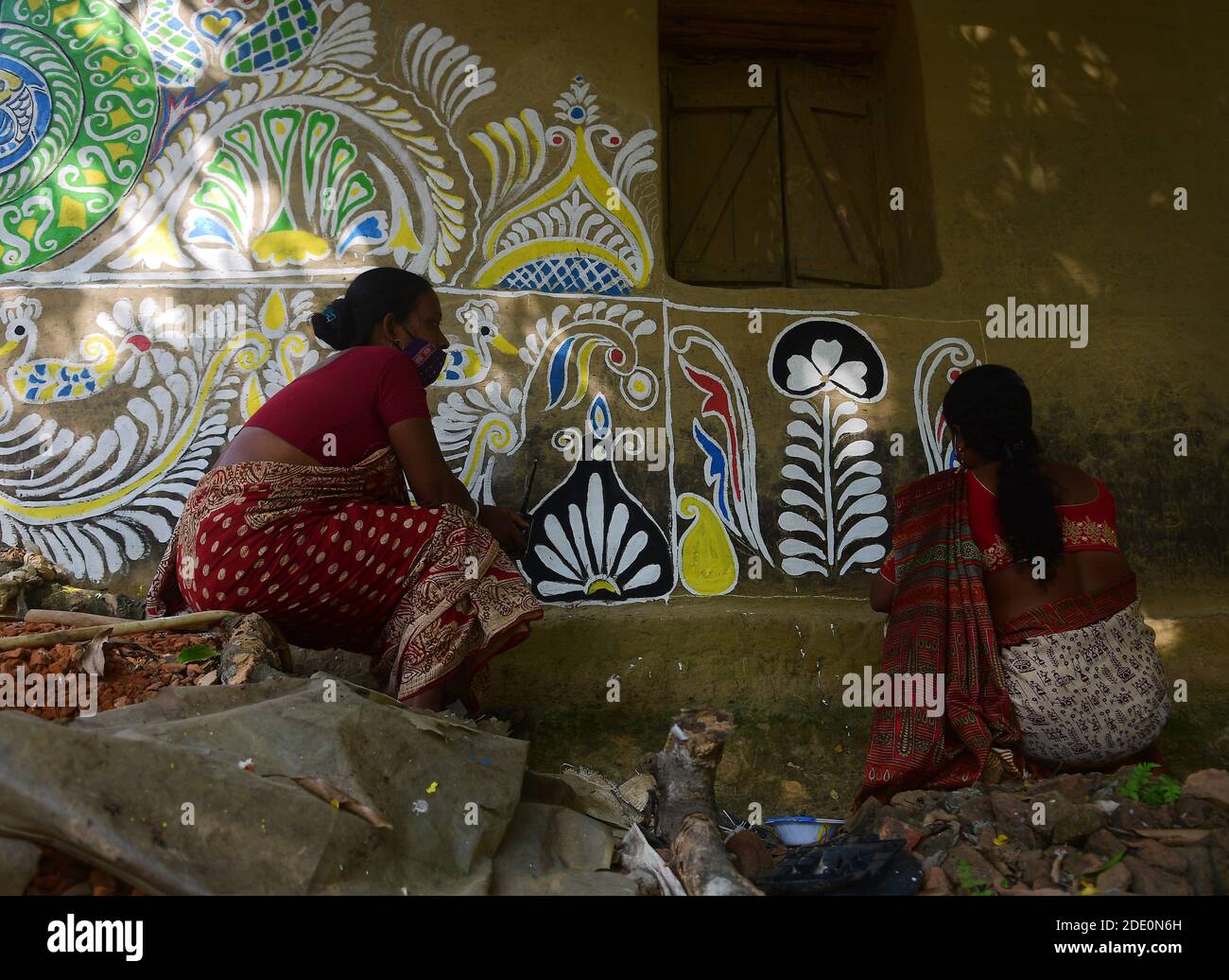 The artisans are doing wall paintings under the observation of Artists