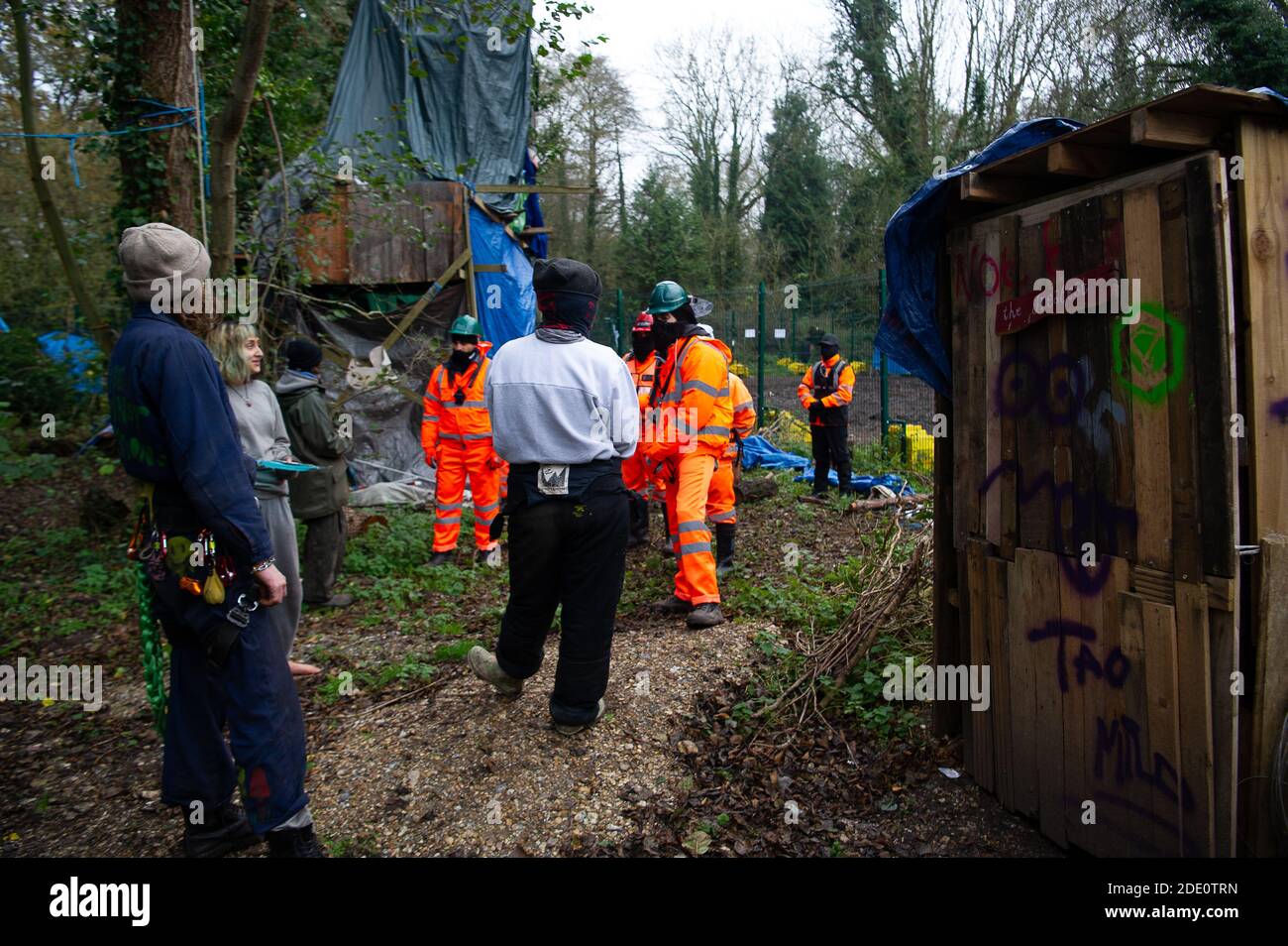 Denham, Buckinghamshire, UK. 27th November, 2020. Today HS2 workers and HS2 security entered the Denham Wildlife Protection Camp in Denham Country Park without permission. The camp is occupied by environmental activists who are living in trees next to an HS2 compound as they try to prevent HS2 from destroying the trees. HS2 arrived in the camp en mass and said it was so they could repair a fence between their compound and the activists camp. Credit: Maureen McLean/Alamy Live News Stock Photo