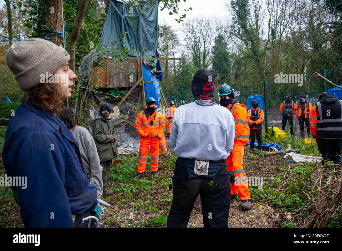 Denham, Buckinghamshire, UK. 27th November, 2020. Today HS2 workers and HS2 security entered the Denham Wildlife Protection Camp in Denham Country Park without permission. The camp is occupied by environmental activists who are living in trees next to an HS2 compound as they try to prevent HS2 from destroying the trees. HS2 arrived in the camp en mass and said it was so they could repair a fence between their compound and the activists camp. Credit: Maureen McLean/Alamy Live News Stock Photo