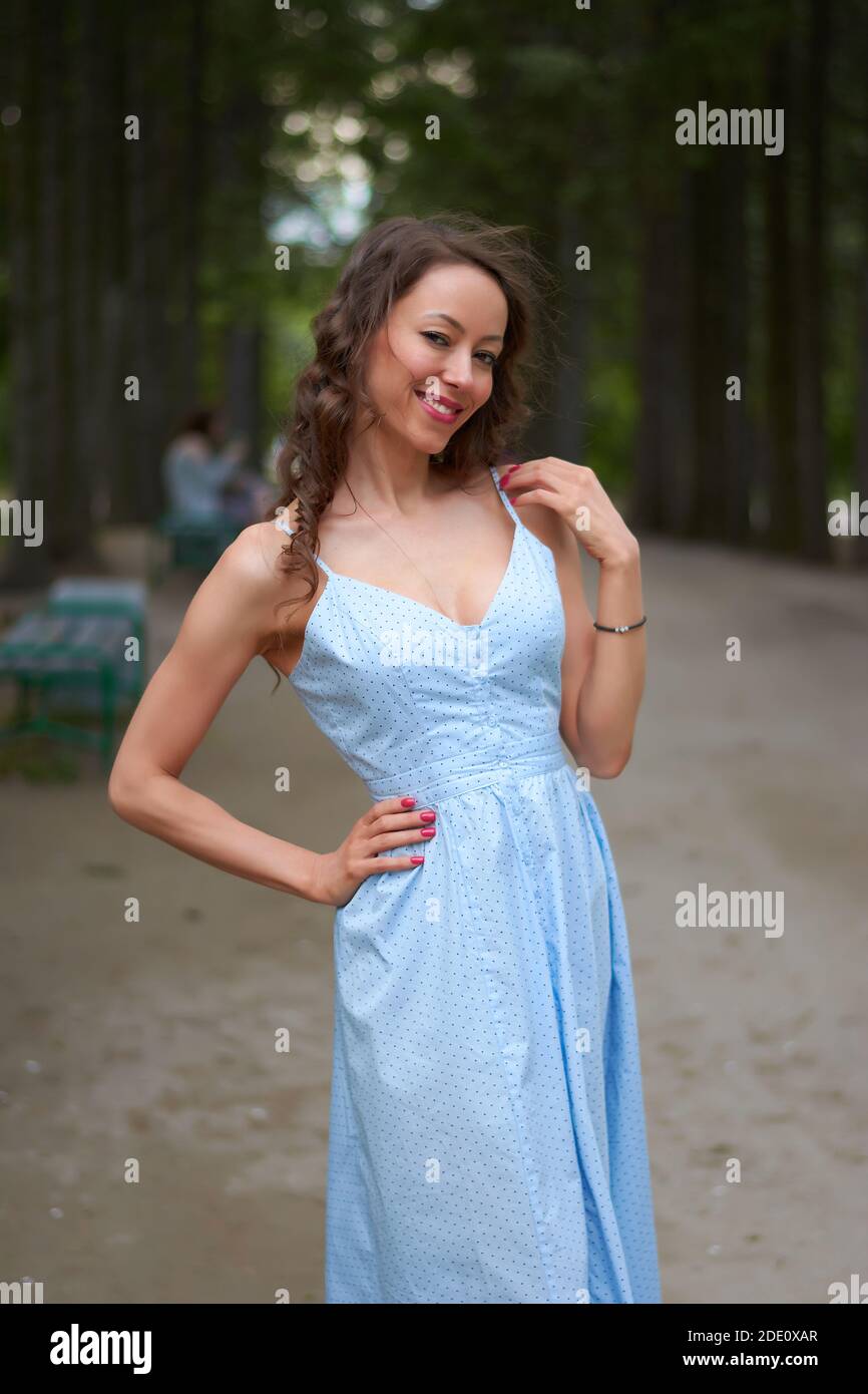 a girl in a blue dress walks in the Park Stock Photo - Alamy