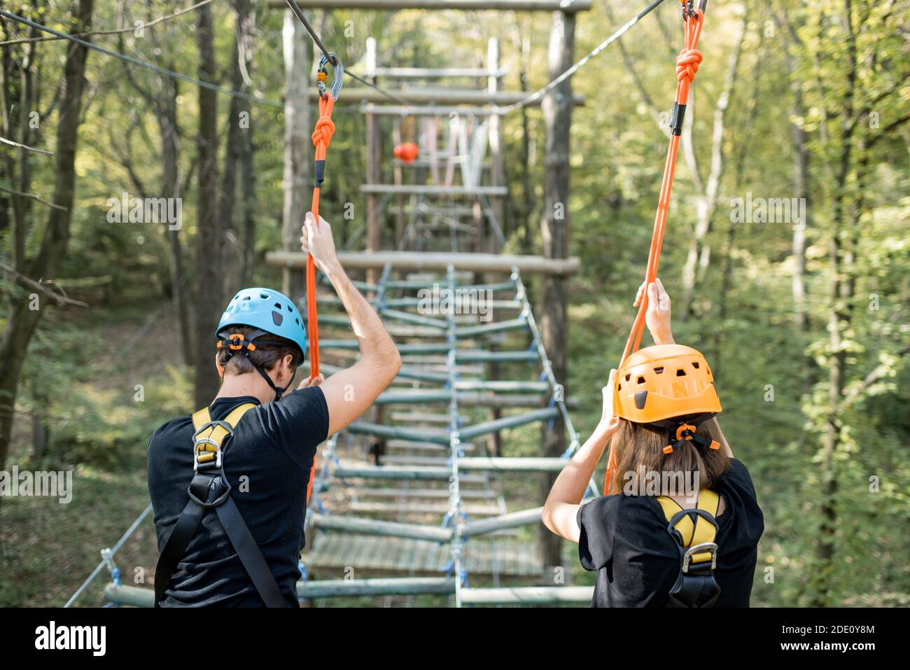 Climbing With Ropes Well-equipped man and woman having an active recreation, climbing ropes ...