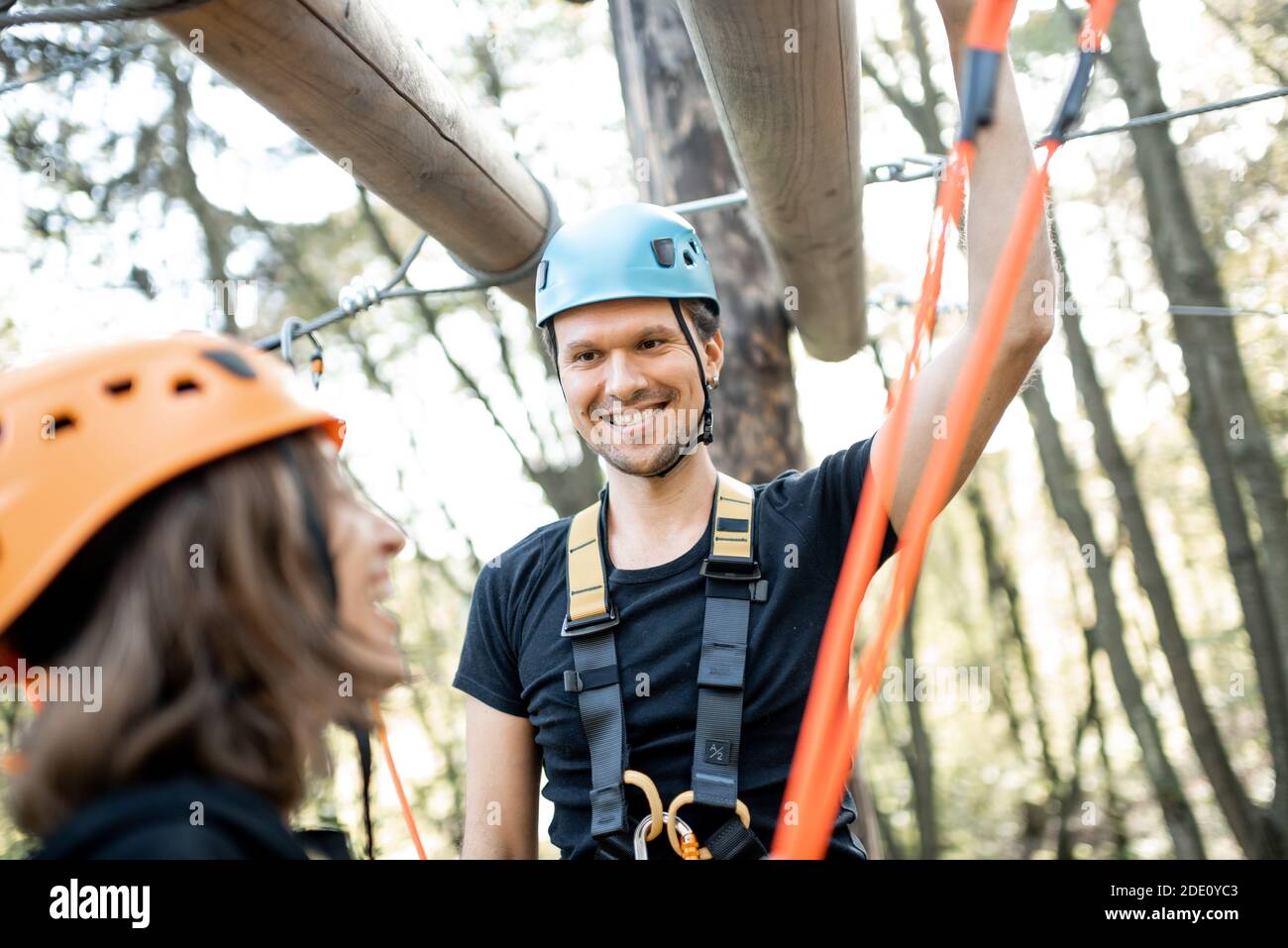 Portrait of a happy well-equipped climbing instructor with a woman in a ...