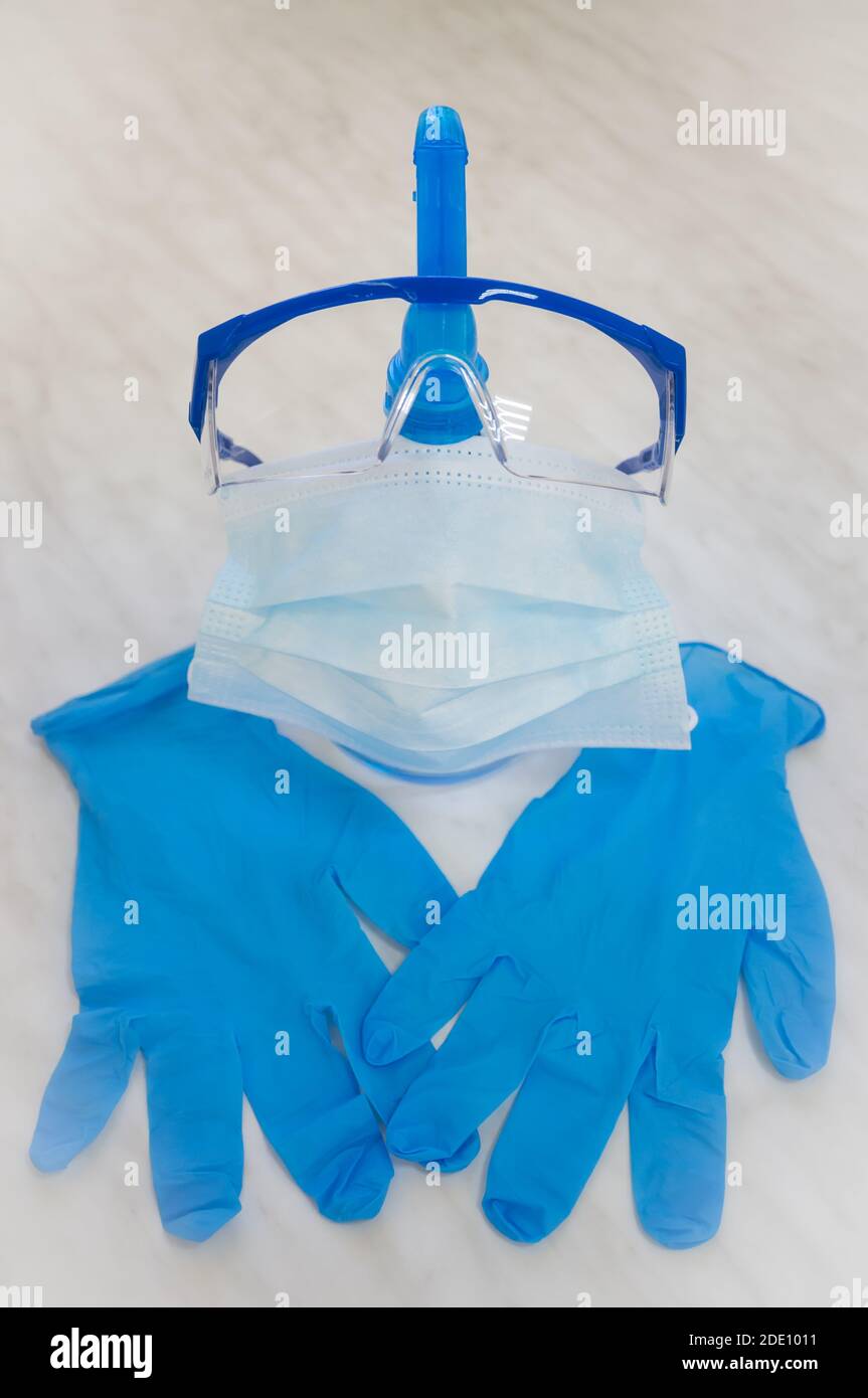 Personal protective equipment during the coronavirus epidemic - goggles, a disposable medical mask, disposable nitrile gloves, a bottle of antiseptic Stock Photo