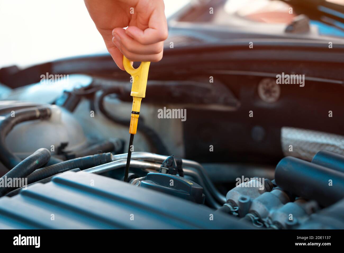 to check car engine oil, using engine oil check stick Stock Photo