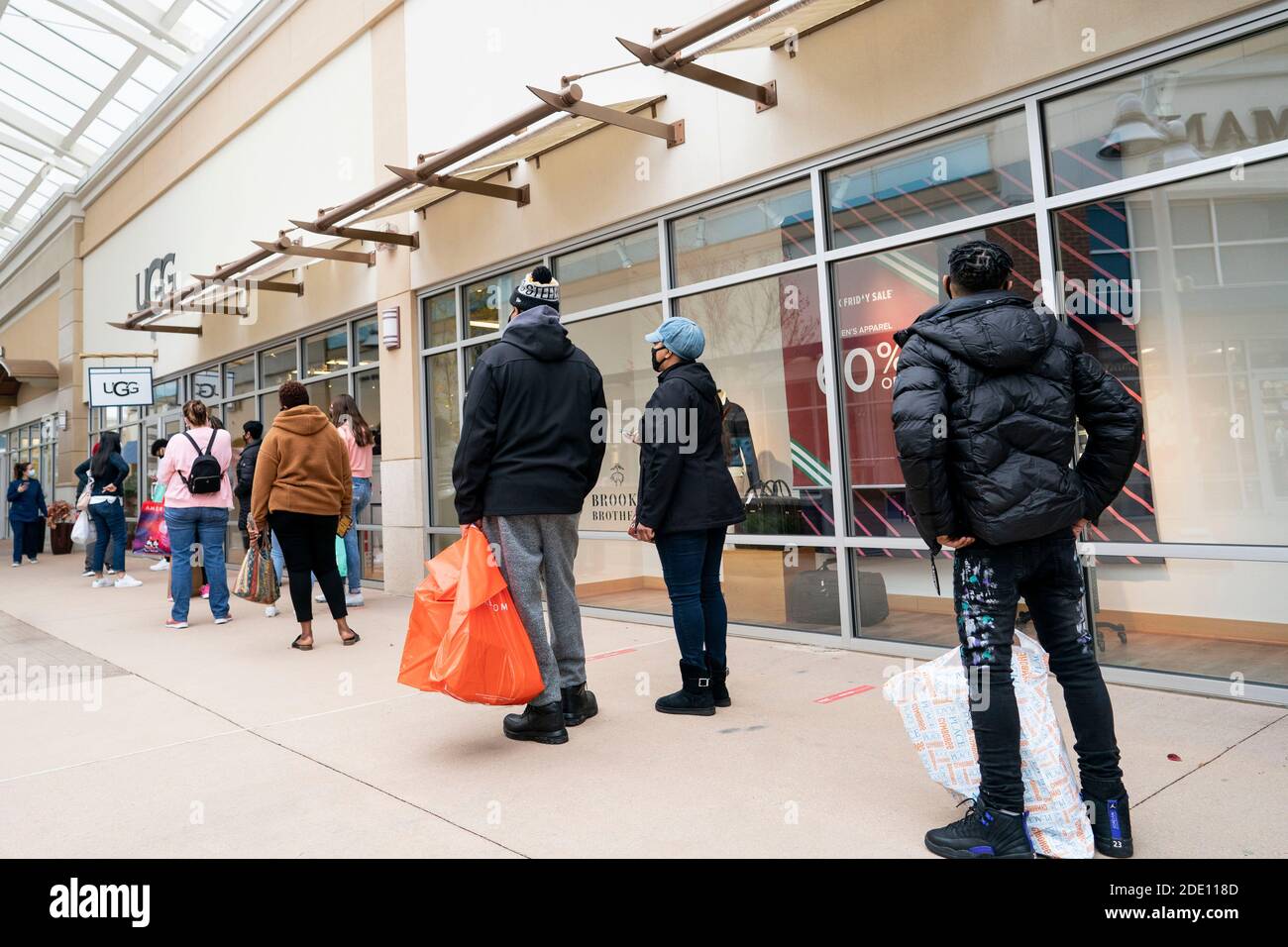 Maryland, USA. 27th Nov, 2020. People line up to enter a store at an outlet mall in Maryland, the United States, on Nov. 27, 2020. U.S. consumers' online spending made a new record high of 5.1 billion U.S. dollars on Thanksgiving Day with a year-on-year growth of 21.5 percent, according to the data issued by Adobe Analytics. 'This year's Black Friday won't have as much 'door-busting' as per usual. Retailers are pushing deals up and promising Black Friday deals to last for 'all of November and December',' said Adobe Analytics. Credit: Liu Jie/Xinhua/Alamy Live News Stock Photo