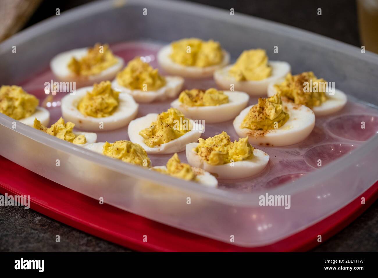 Deviled eggs, prepared and placed in a plastic container for serving at a party. Selective focus Stock Photo
