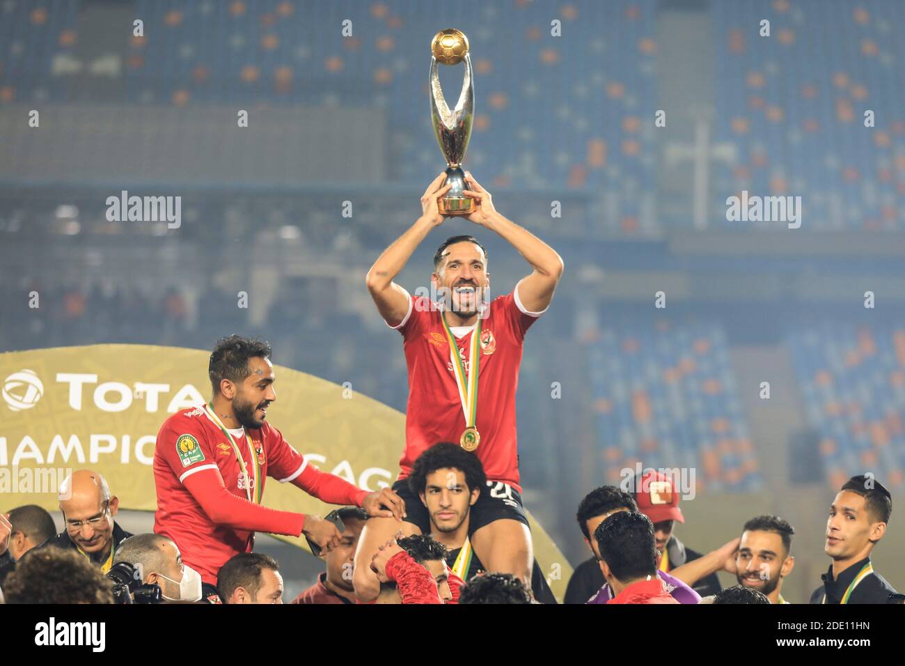 Cairo, Egypt. 27th Nov, 2020. Al Ahly's Ali Maaloul holds up the trophy as his team celebrates winning the African Champions League Final soccer match against Zamalek at Cairo International Stadium. Credit: Sameh Abo Hassan/dpa/Alamy Live News Stock Photo