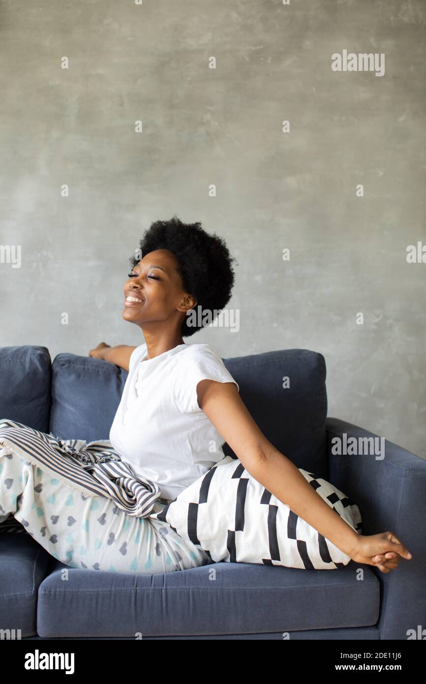 Happy african American young woman wakes up. Happy to move to new ...