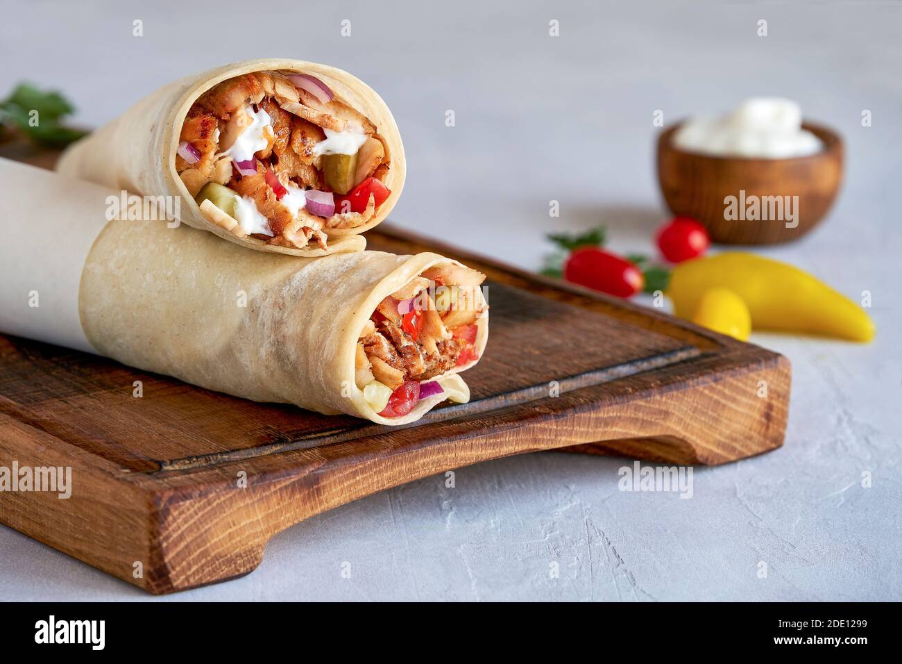 Shawarma with chicken and garlic sauce on wooden board. Closeup Stock Photo