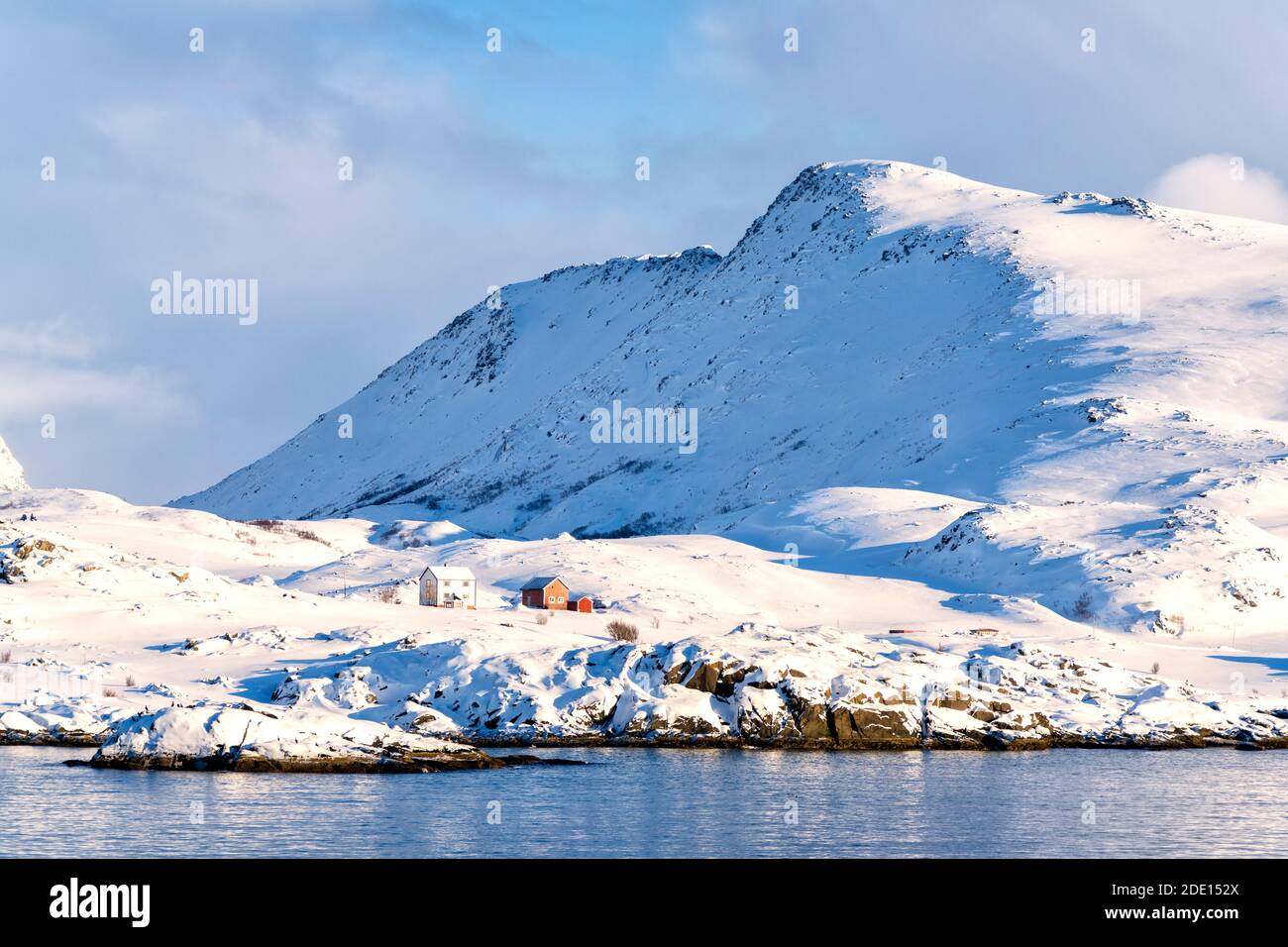 Winter sun over isolated fishermen huts in the snow, Hasvik, Soroya Island, Troms og Finnmark, Arctic, Northern Norway, Scandinavia, Europe Stock Photo