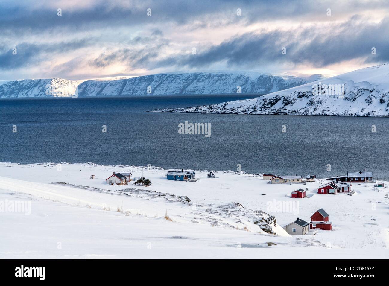 Fishing village of Honningsvag covered with snow surrounded by the icy sea, Nordkapp, Troms og Finnmark, Northern Norway, Scandinavia, Europe Stock Photo