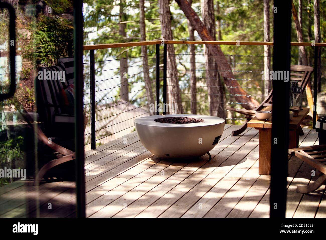 View on a sunlit deck with a firepit from the room Stock Photo