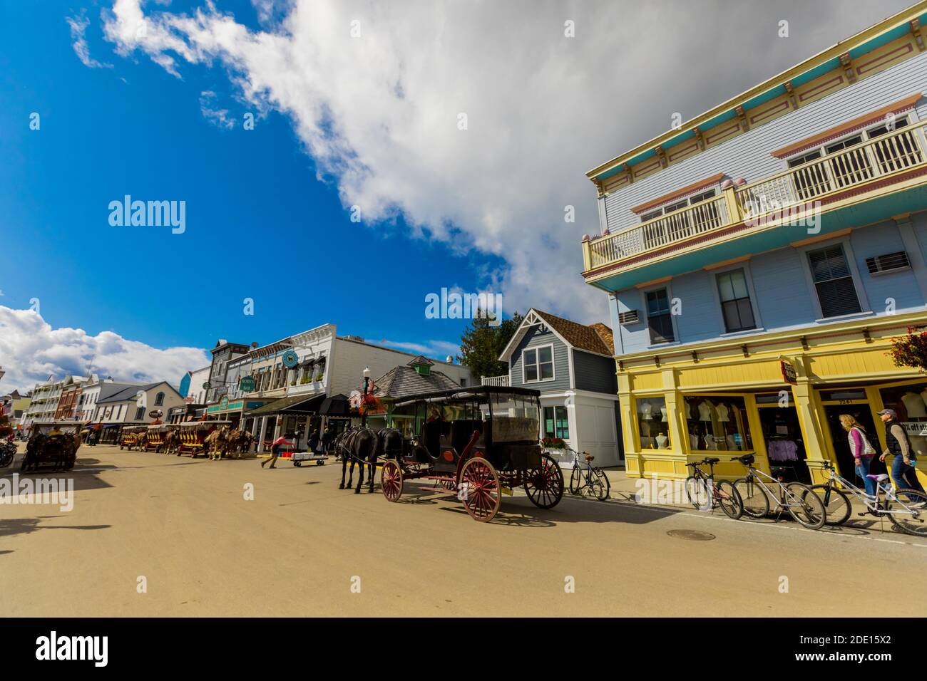 Horse and carriage filled streets lined with beautiful colorful buildings, Mackinac Island, Michigan, United States of America, North America Stock Photo