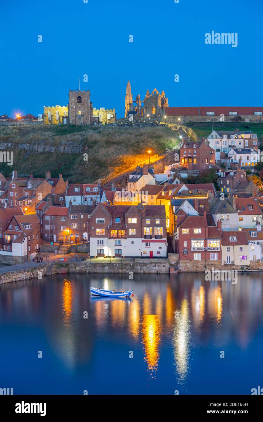 View of St. Mary's Church and Whitby Abbey from across River Esk at dusk, Whitby, Yorkshire, England, United Kingdom, Europe Stock Photo
